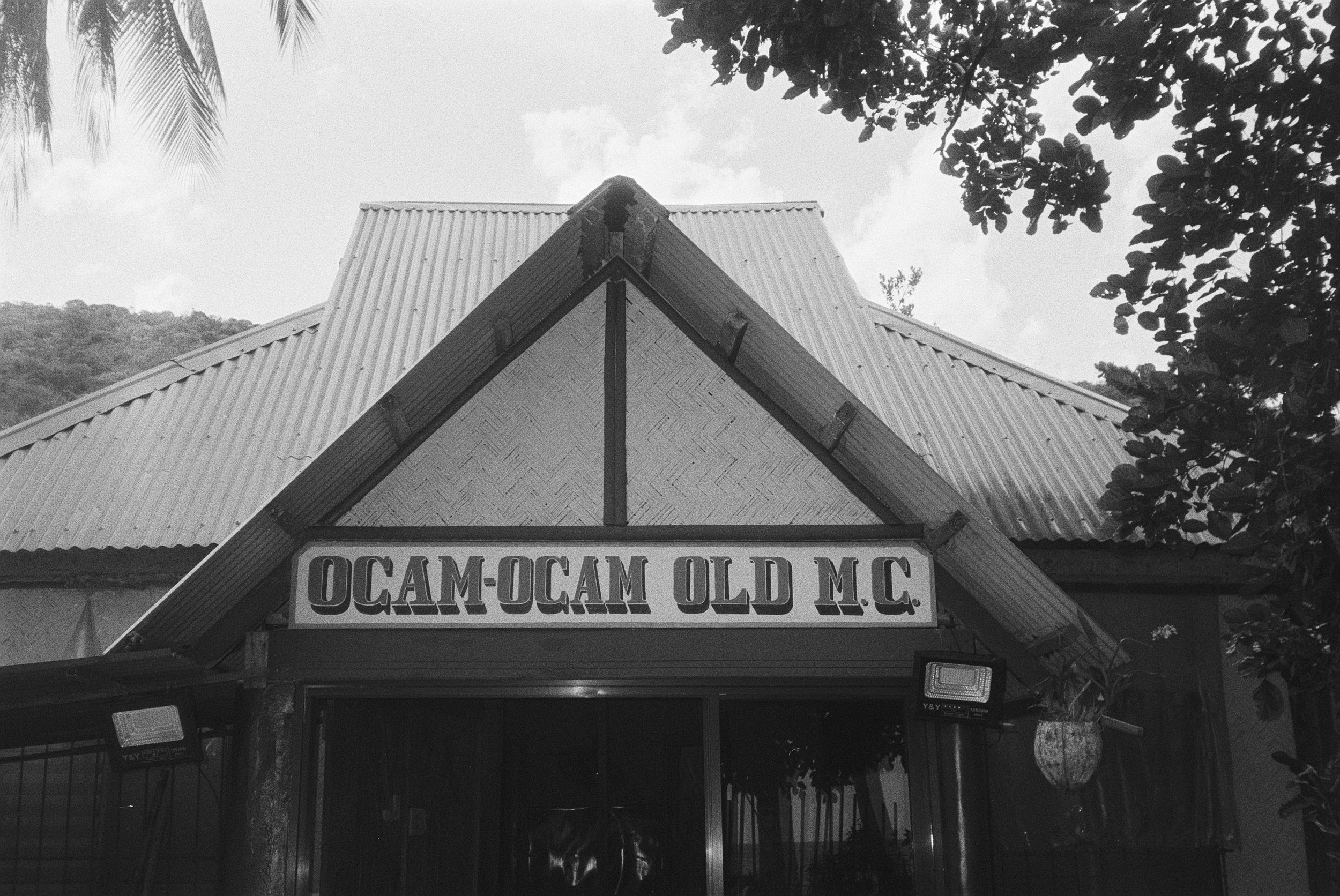 Schilder an einem Gebäude mit der Aufschrift 'OCAM-O CAM OLD M.C.'.