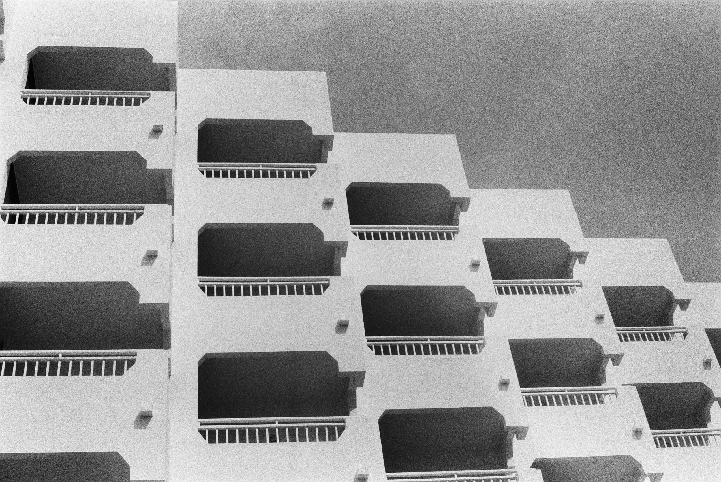 Schwarz-weiß-Fotografie eines modernen Gebäudes mit mehreren Balkonen