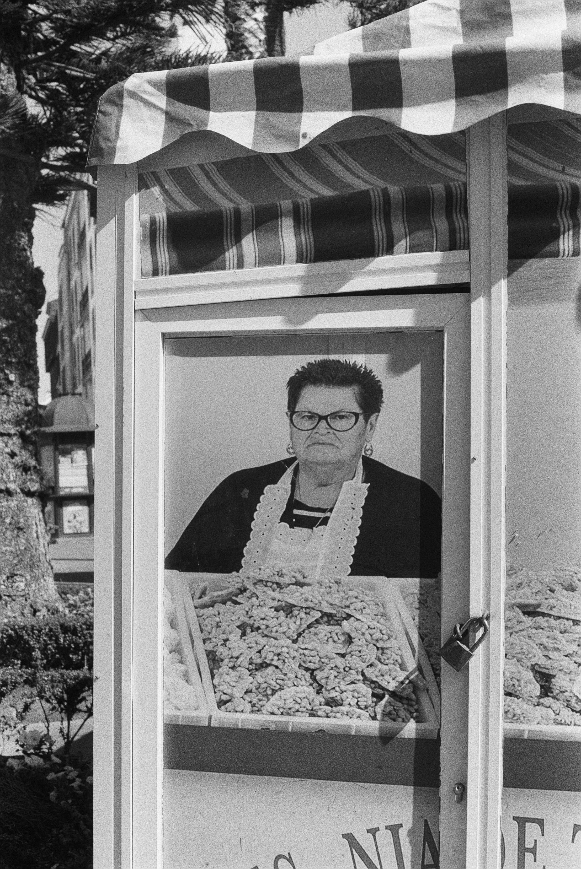 Ein schwarzes und weißes Foto eines großen Plakats mit einem Bild einer Frau, die eine Schürze trägt und eine Schüssel mit Gegenständen hält.