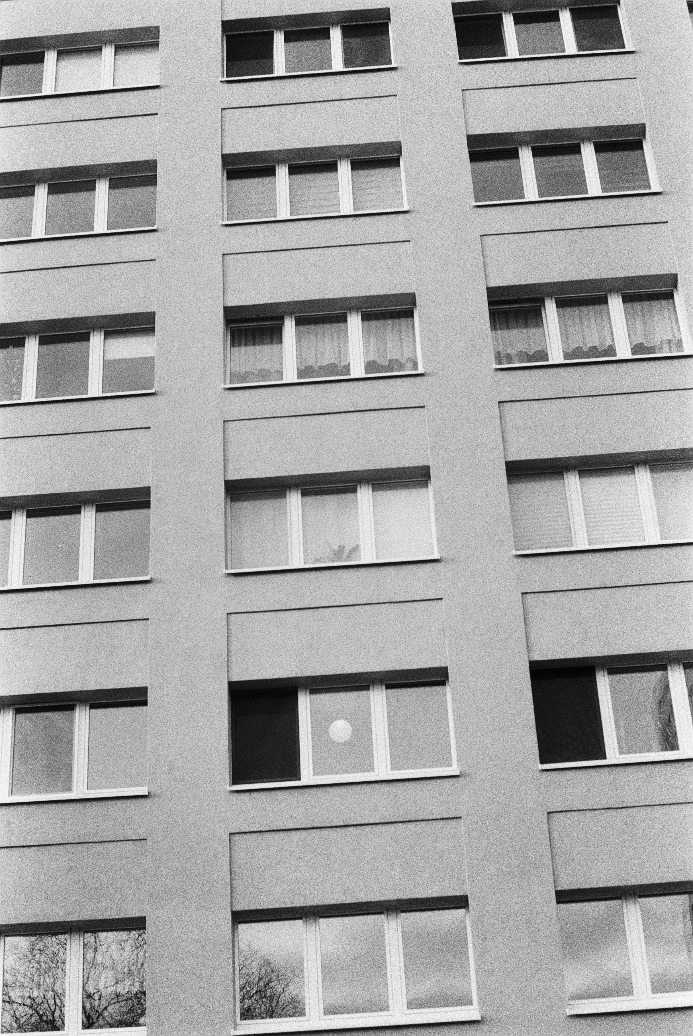 Schwarz-weiß-Foto eines modernen Mehrfamilienhauses mit mehreren Fenstern.