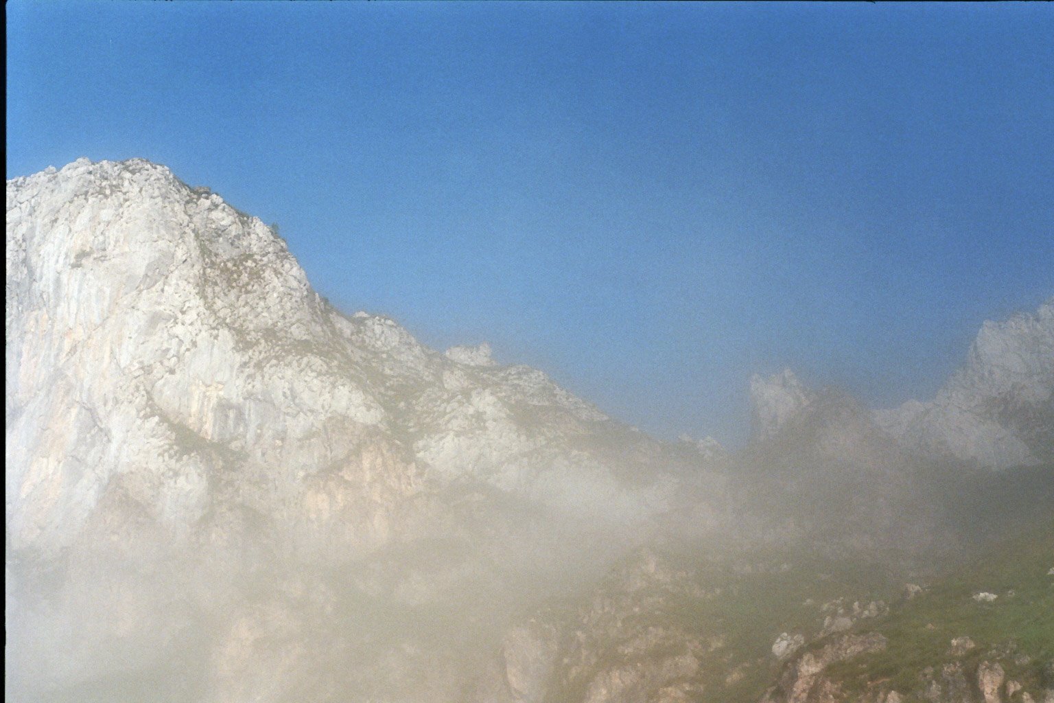 Berggipfel im Nebel mit blauem Himmel