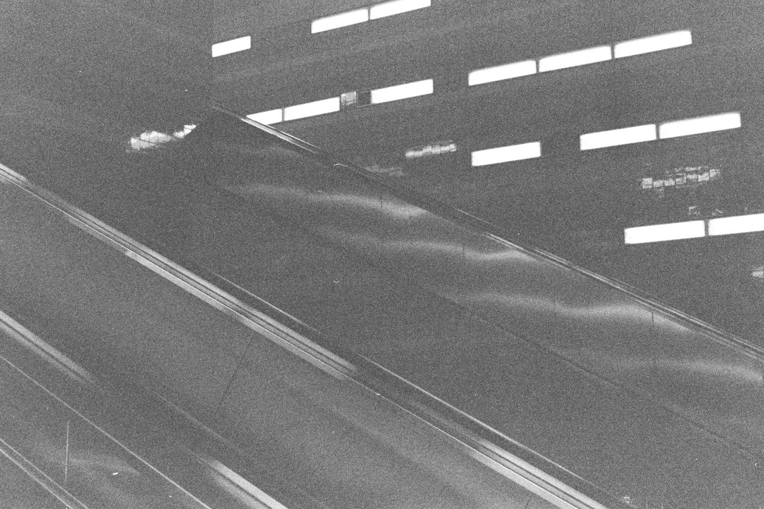 Schwarz-weiß-Fotografie eines Aufzugs mit Metallgriffen und digitalen Anzeigen.
