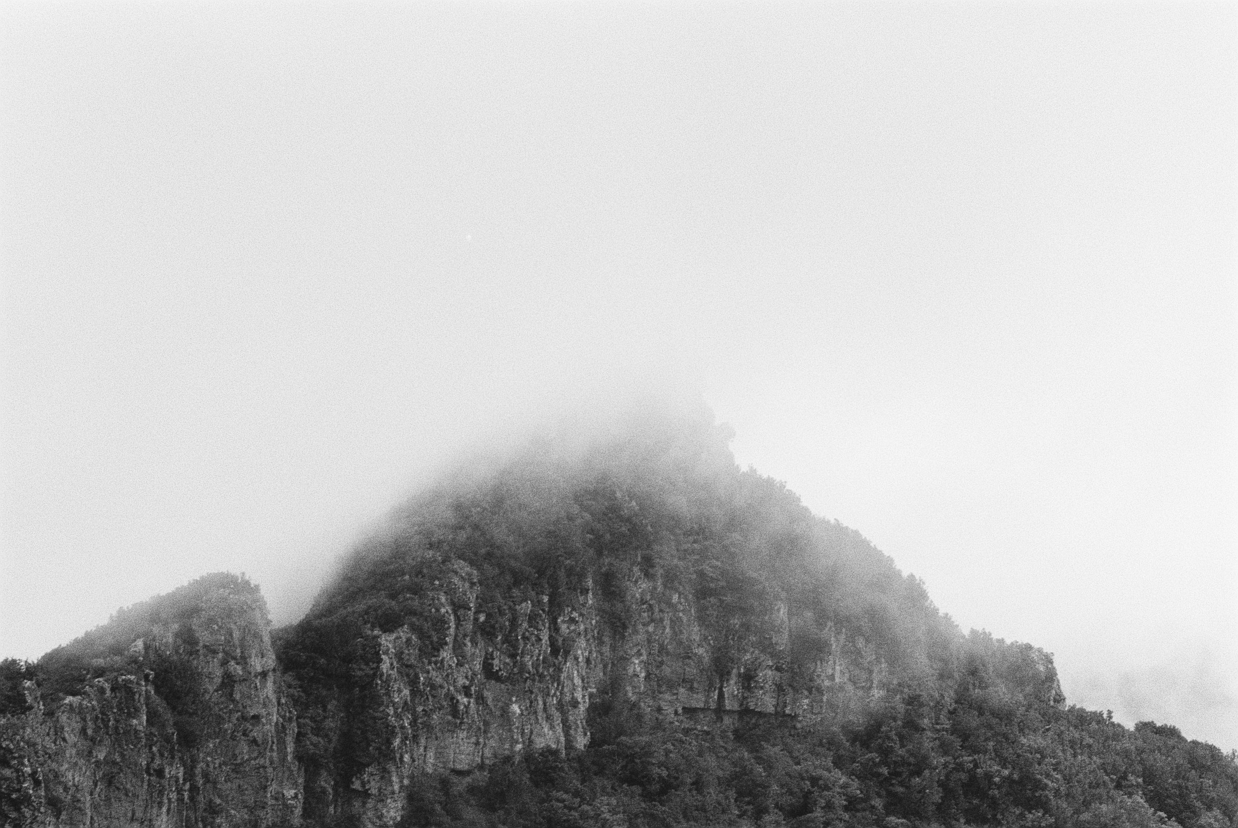 Berg mit bewölktem Himmel in Schwarz-Weiß