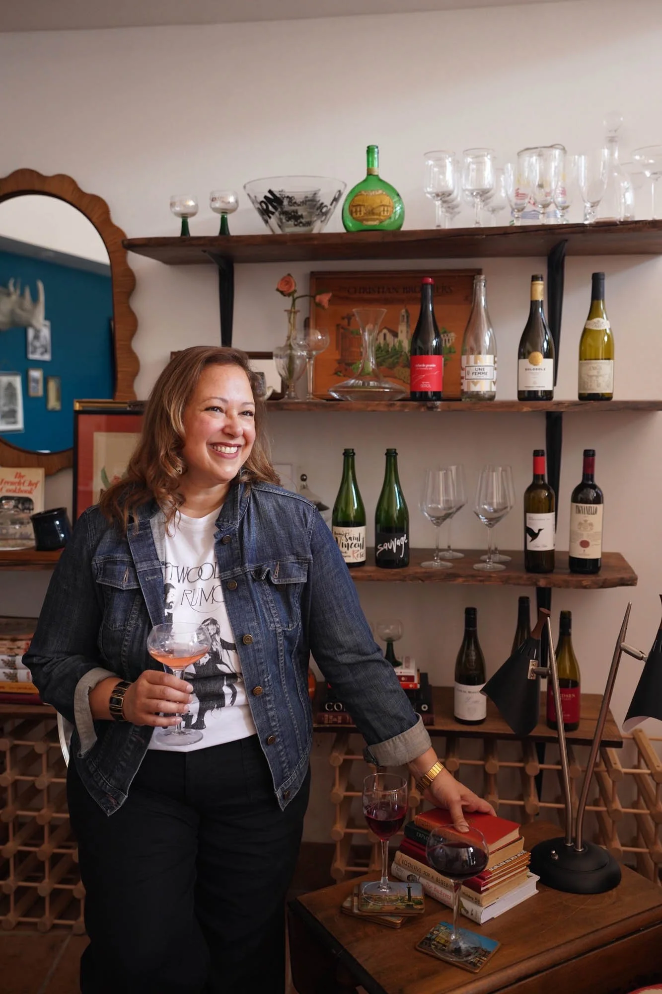 Owner of Kinship Wine + Wares standing in store with glass of wine