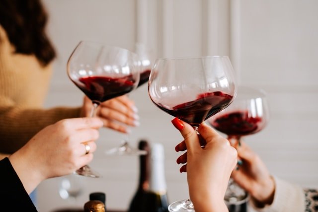 Hands cheers with wine glasses