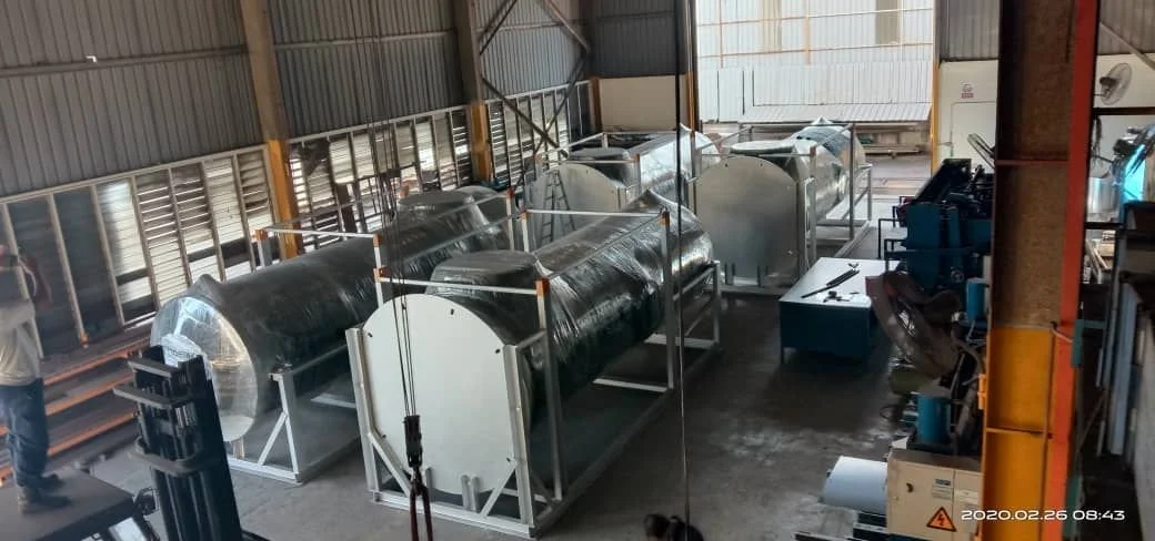 Industrial storage area with tanks, machinery, and tools inside a warehouse.