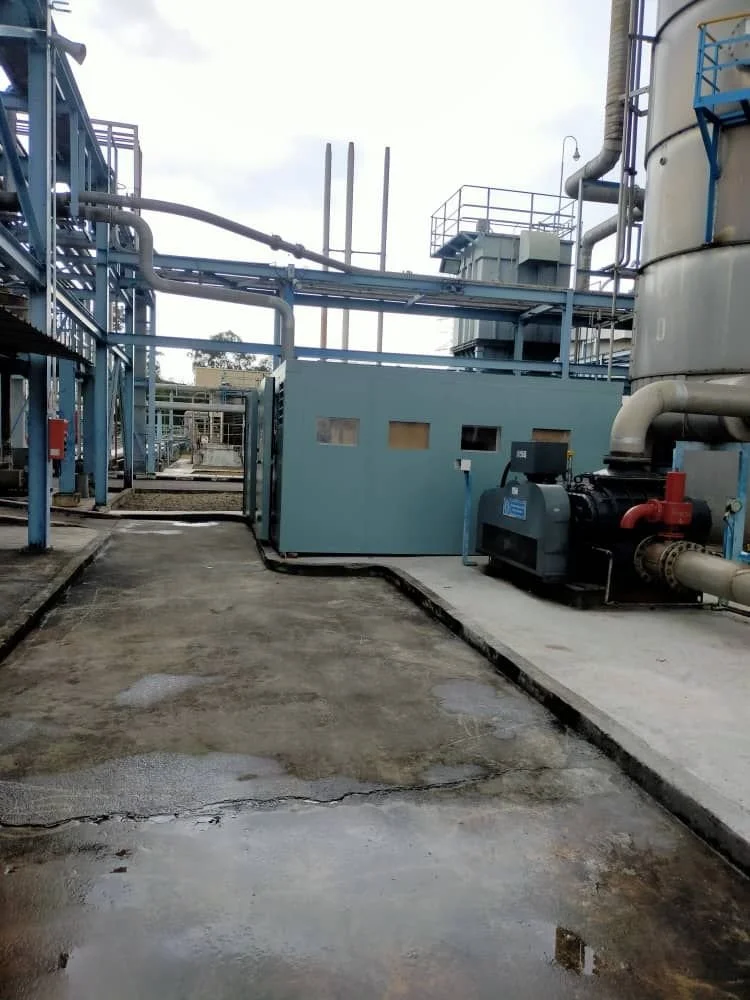 Industrial facility with large machinery, pipes, and walkways.