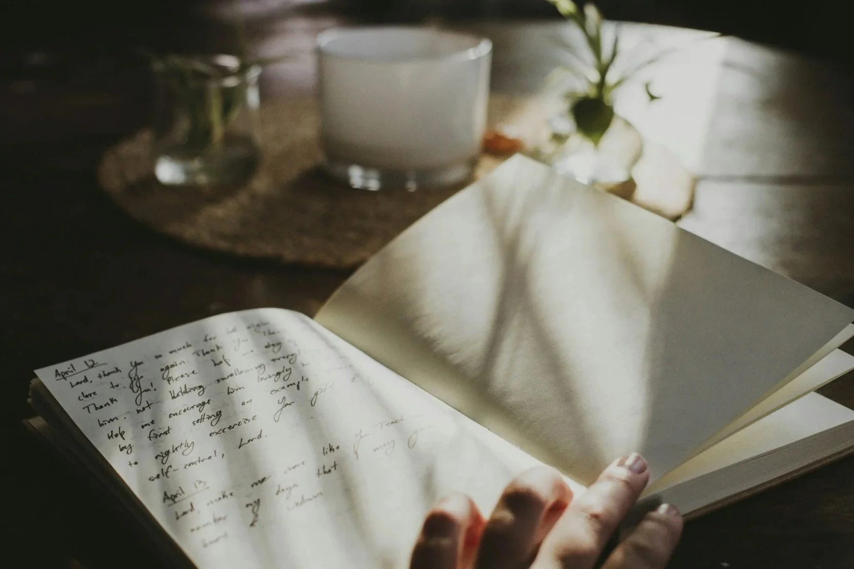 Open book beside a cup of tea in soft natural light, reflecting the calm atmosphere of A Place To Soften.