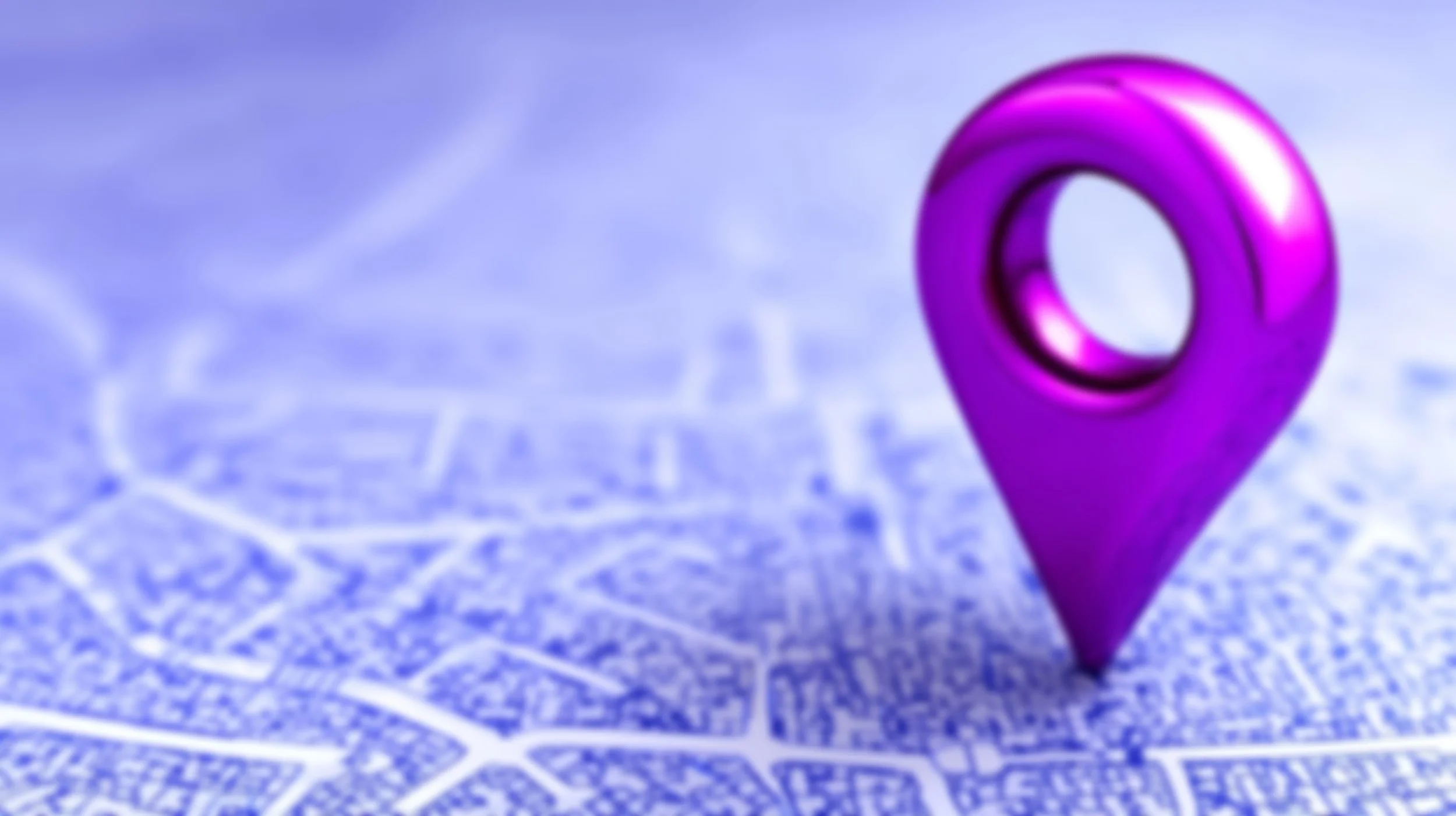 A vivid purple local marker sits atop a blue-and-white street grid, which fades out of focus as the foreground gives way to the blurrier background.