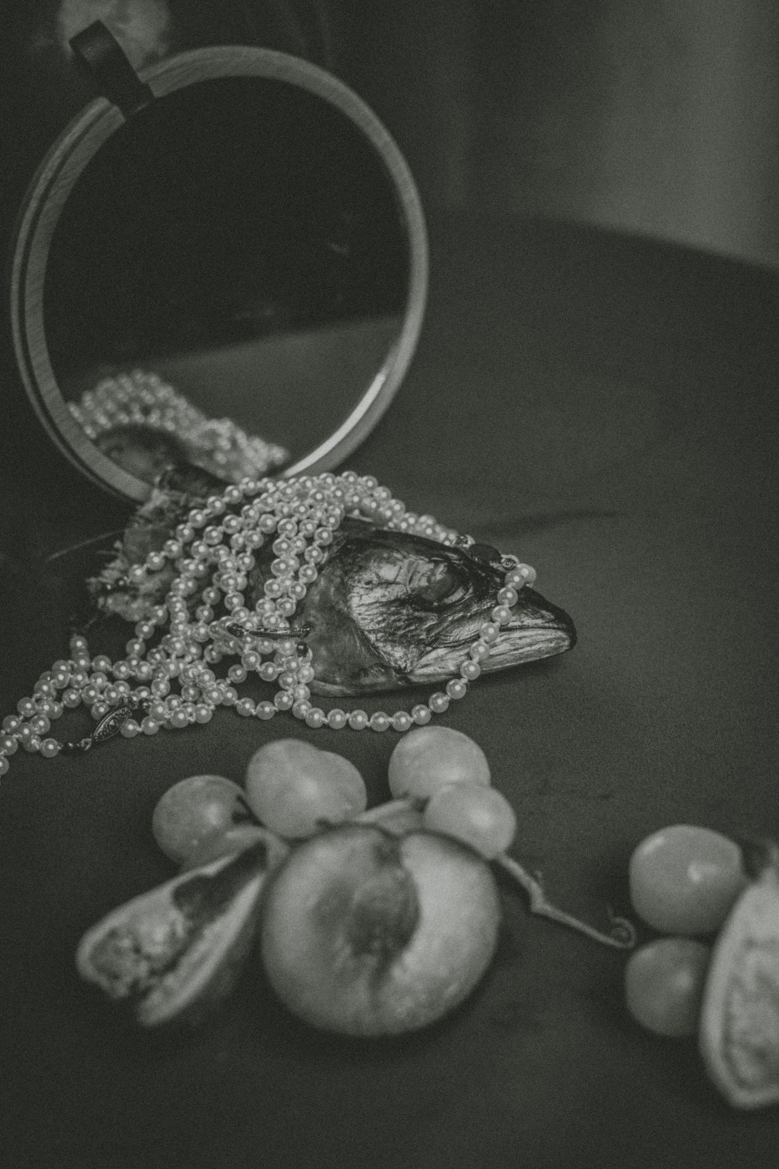Close-up of jewelry including pearl necklaces, bracelets, and rings, with an open jewelry box and some spherical objects in the foreground.