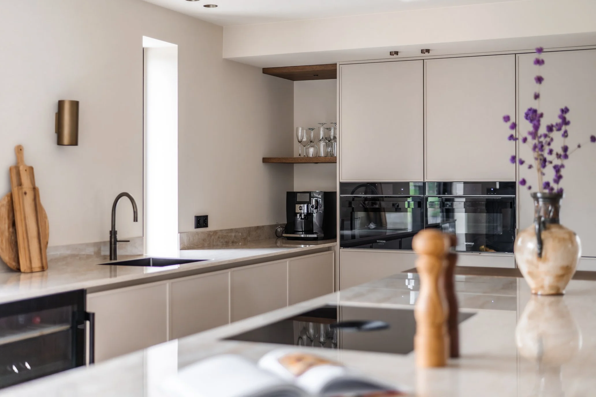 Luxe maatwerk keuken met spuitwerk, donker eiken fineer, open vakken en Dekton werkblad.