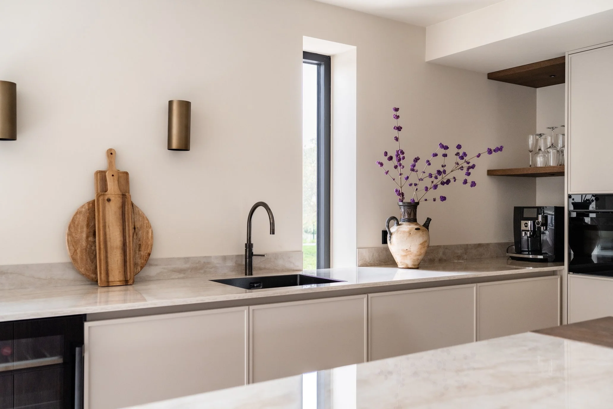 Luxe maatwerk keuken met spuitwerk, Dekton werkblad, Quooker kraan en eiken wandplanken.