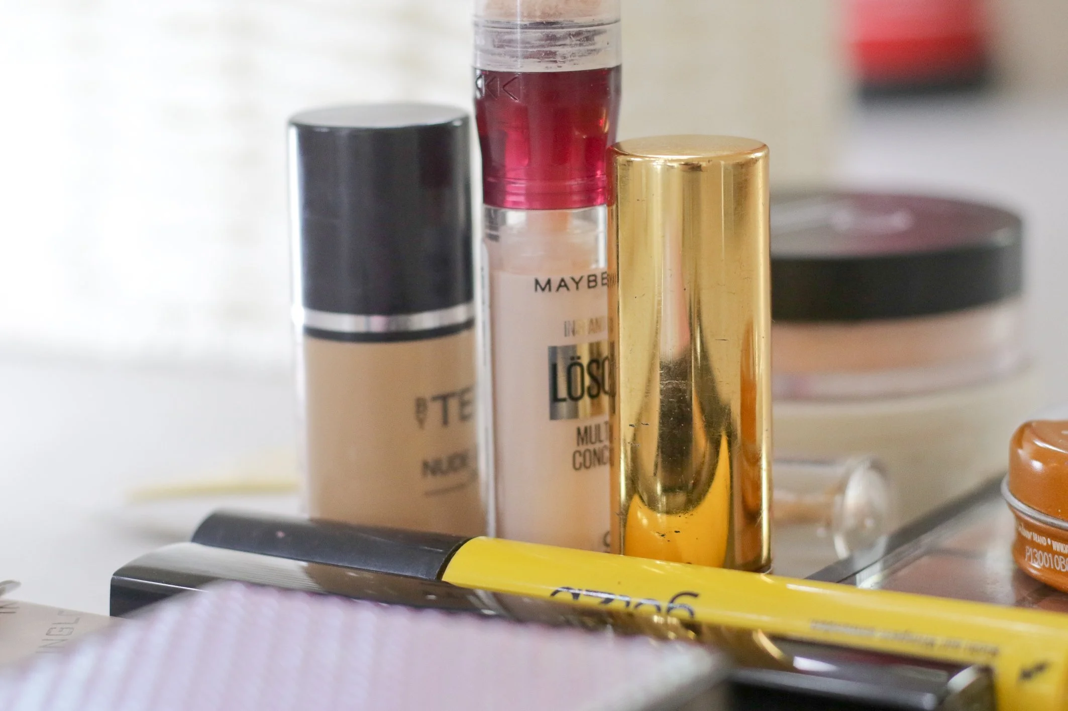 Verschiedene Make-up Produkte, darunter Lippenstifte und Lipgloss, auf einer Oberfläche