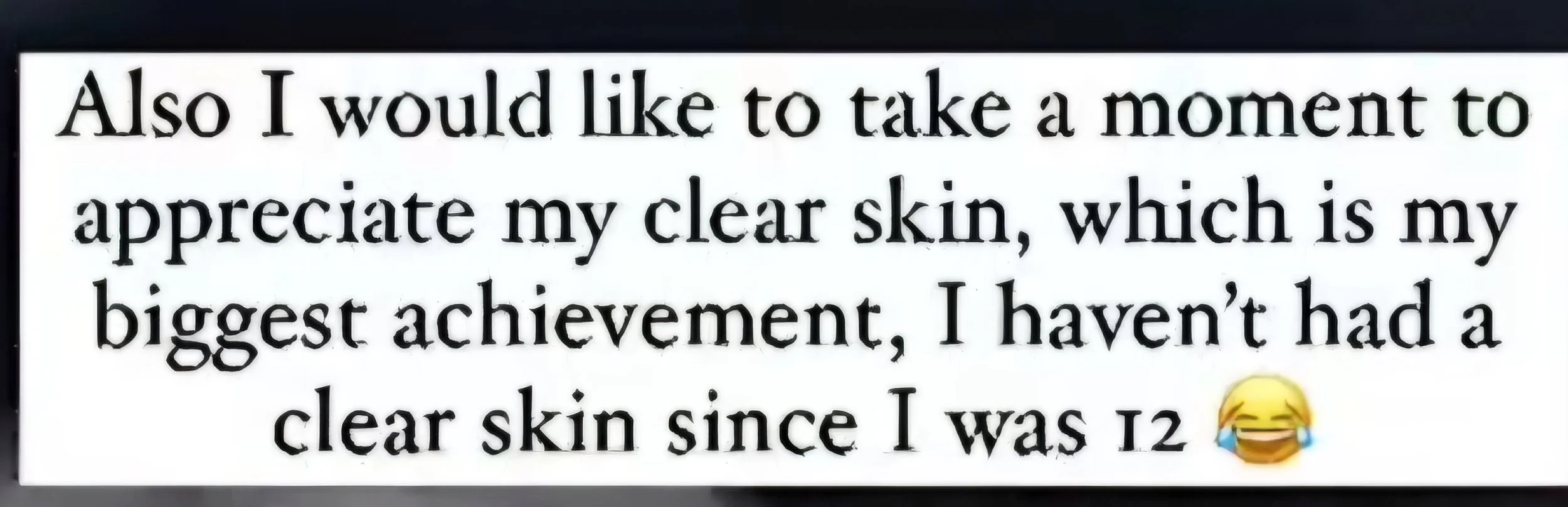 Sign with text about appreciating clear skin and humorously mentioning not having had clear skin since age 12, with a laughing with tears emoji.