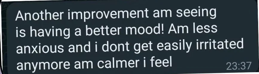 A digital message or chat comment about feeling happier and calmer, mentioning improvements in mood and reduced anxiety.