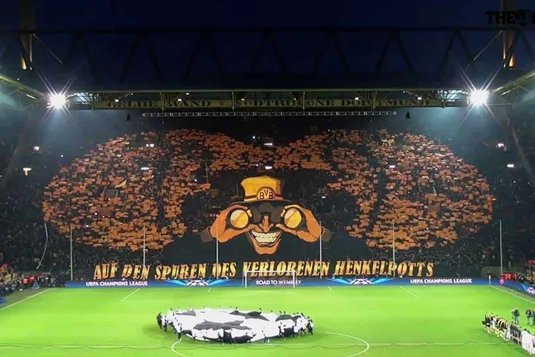 Signal Iduna Park football stadium home of Borussia Dortmund, filled with football fans holding yellow and black cards, creating a large display of a mascot or symbol.