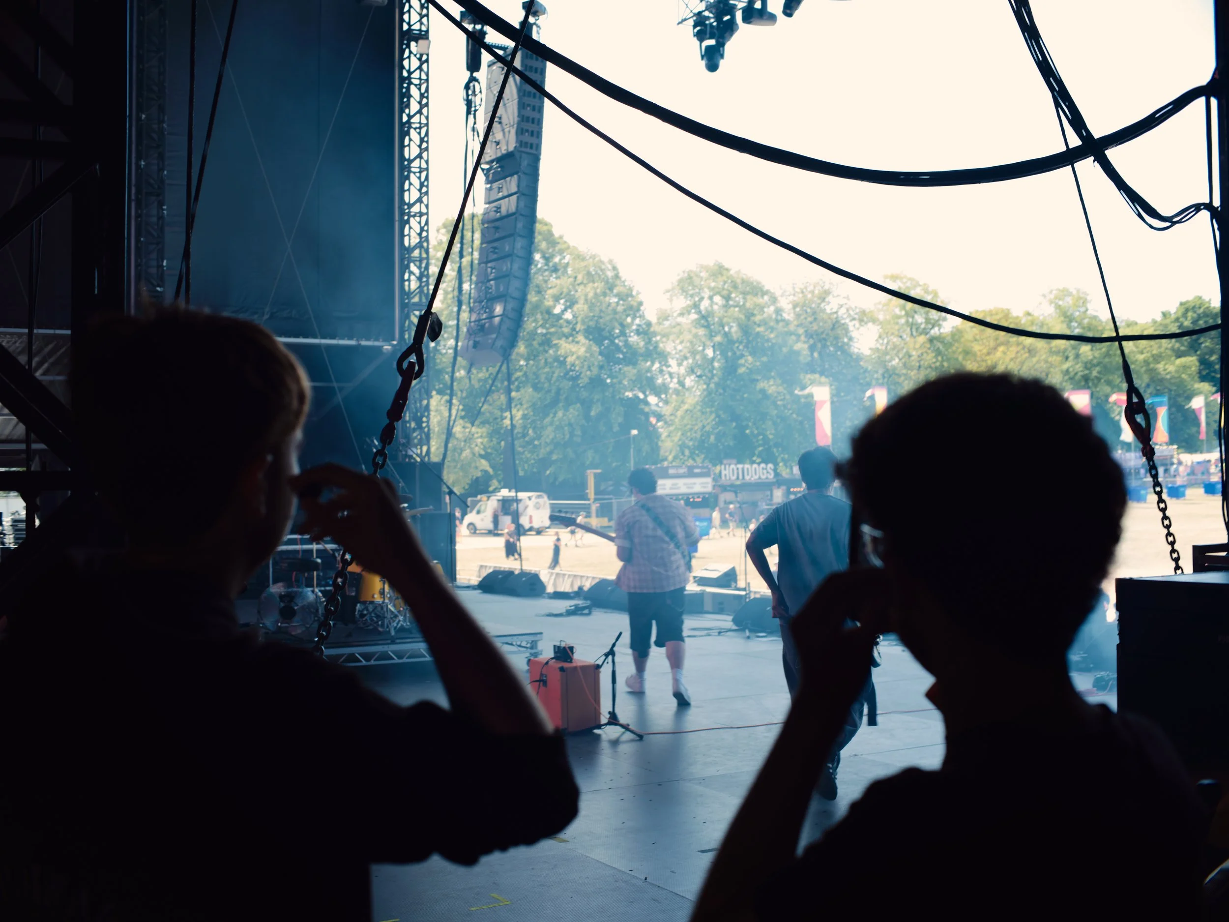 A drum tech watching side stage during the bands performance on a festival main stage.