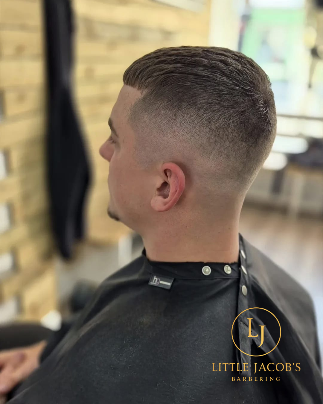 Side view of a man with a fresh textured fade haircut at Little Jacob's Barbering shop.
