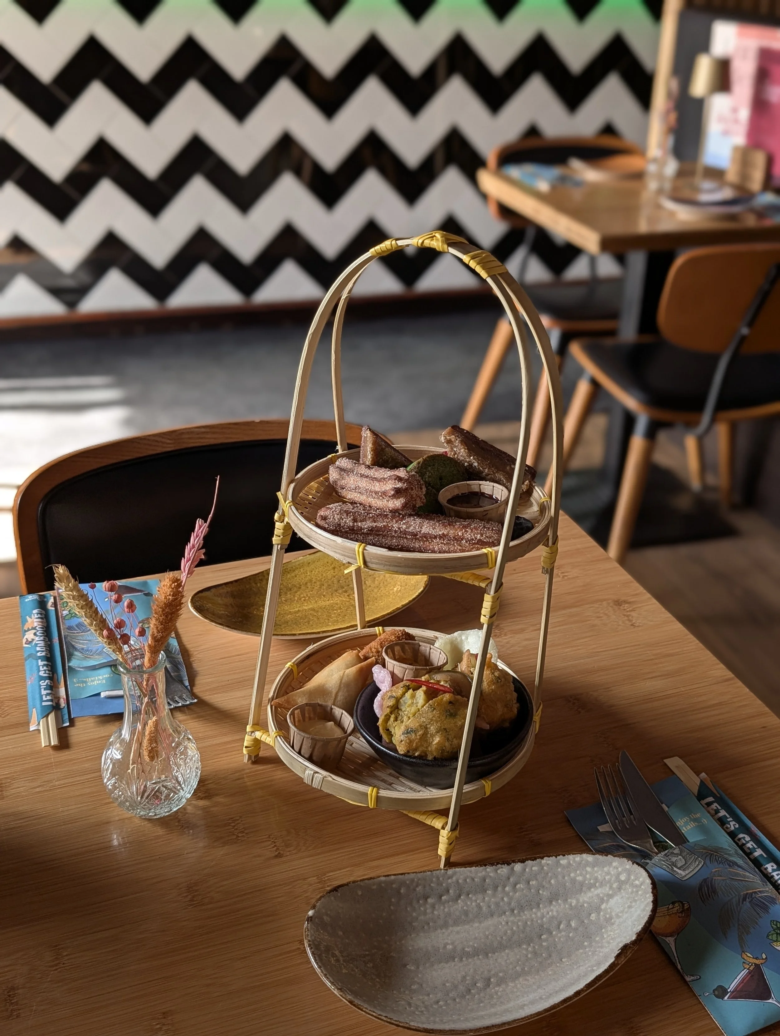Een High Tea etagère met verschillende zoete hapjes en hartige snacks op een tafel in restaurant The Bamboo Room