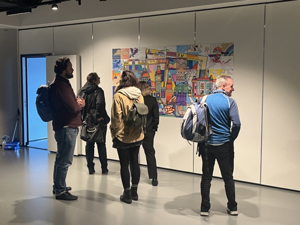 Group of people standing in front of a colorful cityscape painting in an art gallery.