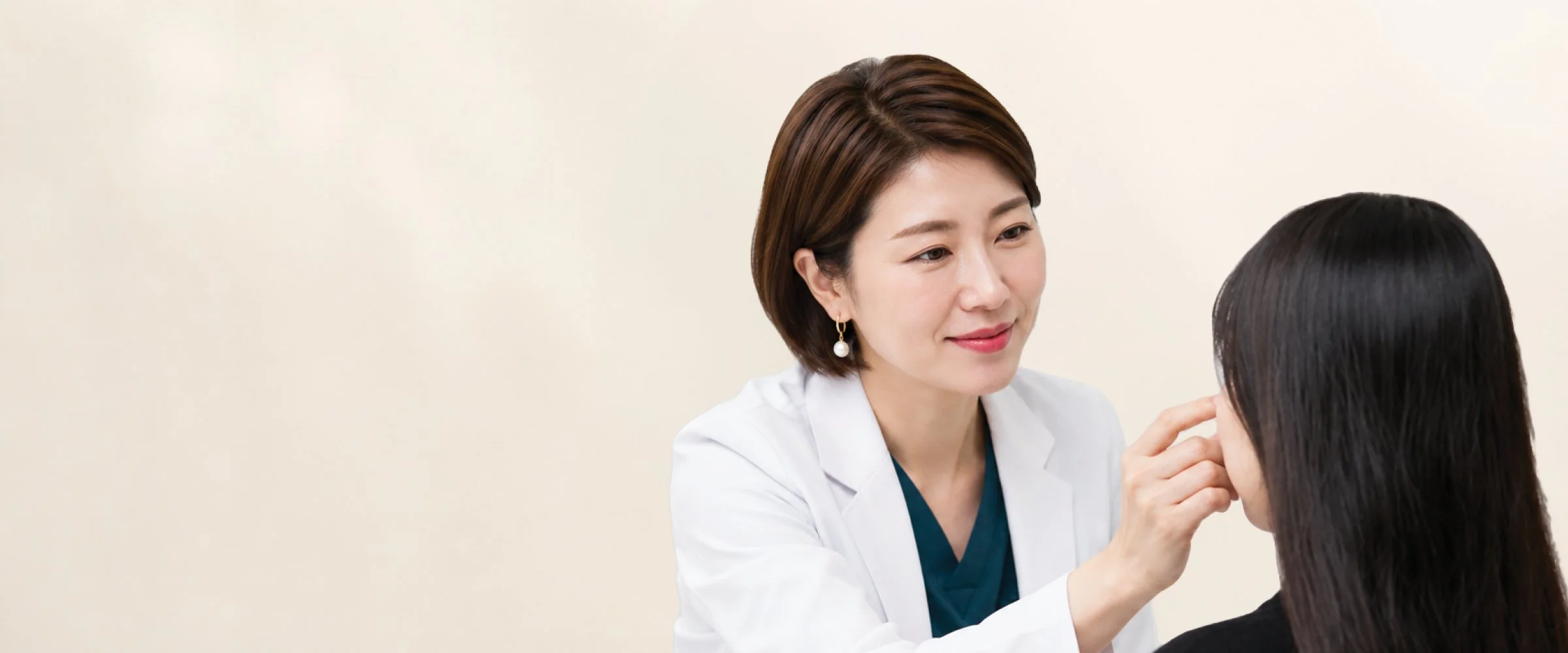 Medical professional examining patient's face in consultation.