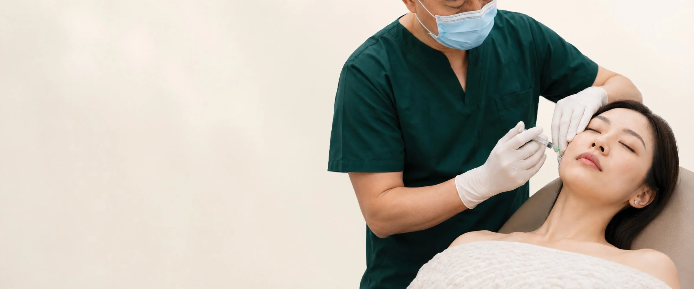 Medical professional administering a cosmetic injection to a woman's face in a clinical setting.