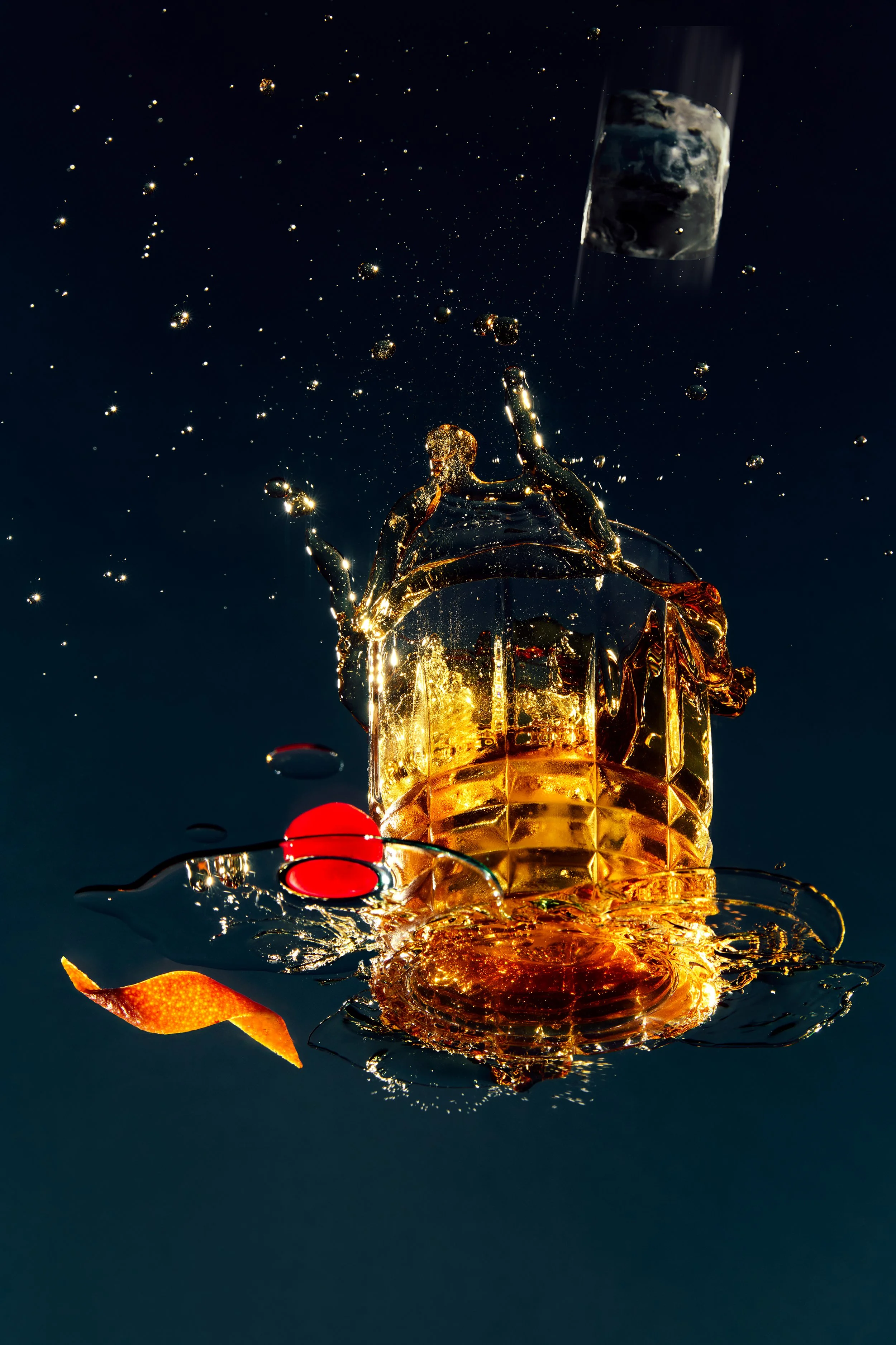A glass of whiskey splashing water with bubbles and reflections, orange peel garnish, and a dark background.
