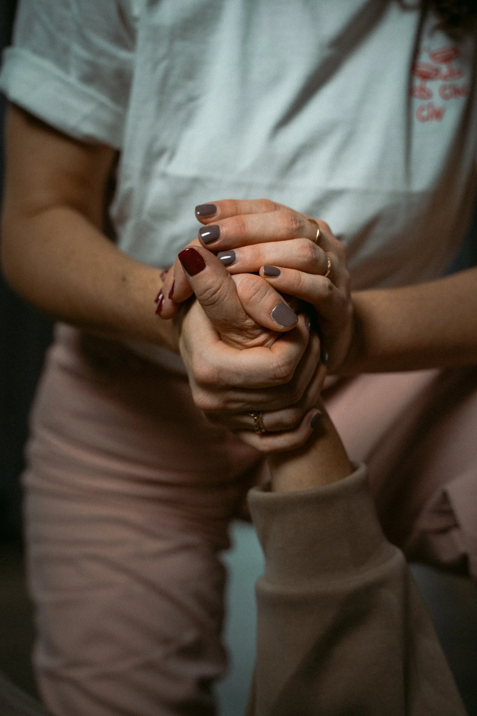 Schnappschuss aus einer Bodywork Session: zwei Hände umgreifen fest aber liebevoll eine andere Hand.