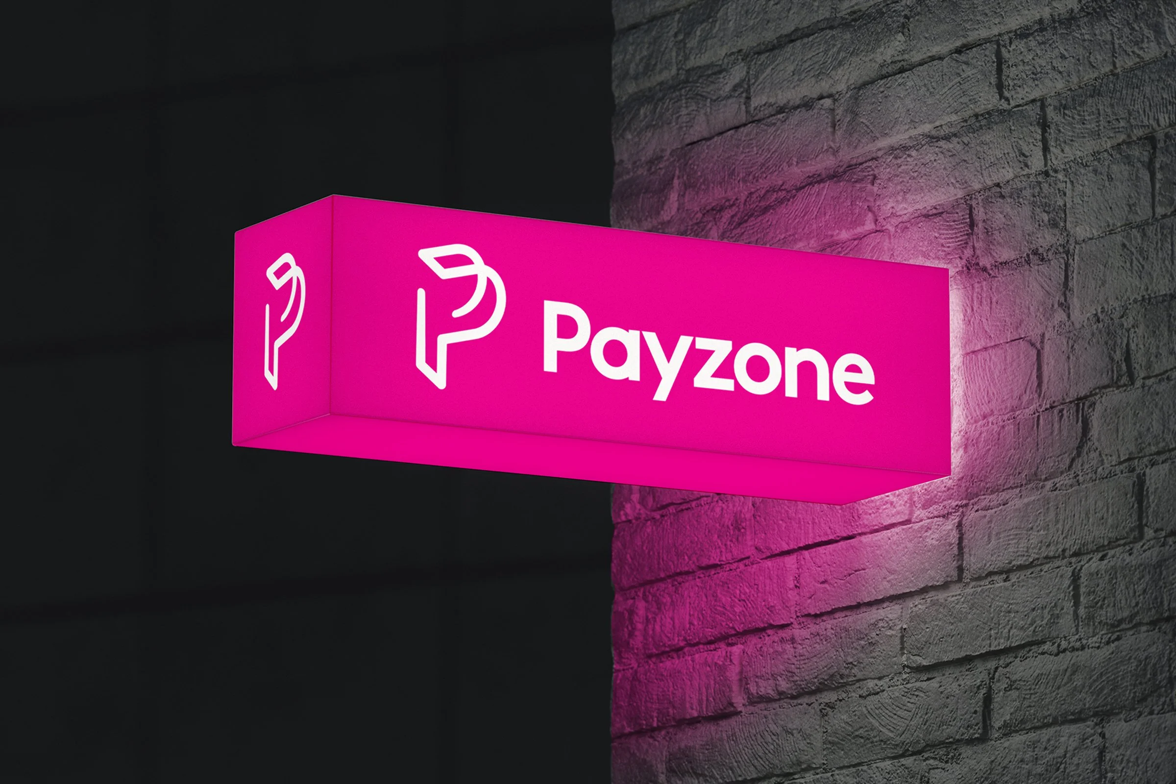 Payzone Retail. Pink illuminated sign with the word "Payzone" and a symbol of a payphone, mounted on a textured gray brick wall.