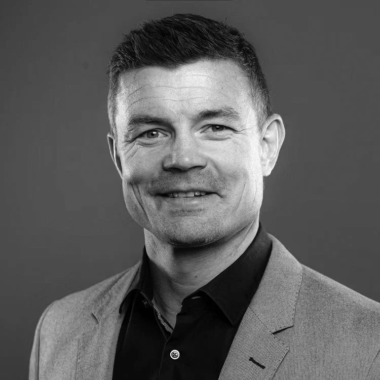 Brian O'Driscoll Headshot photo of a smiling man wearing a suit jacket and dark shirt, with short, dark hair against a plain background.