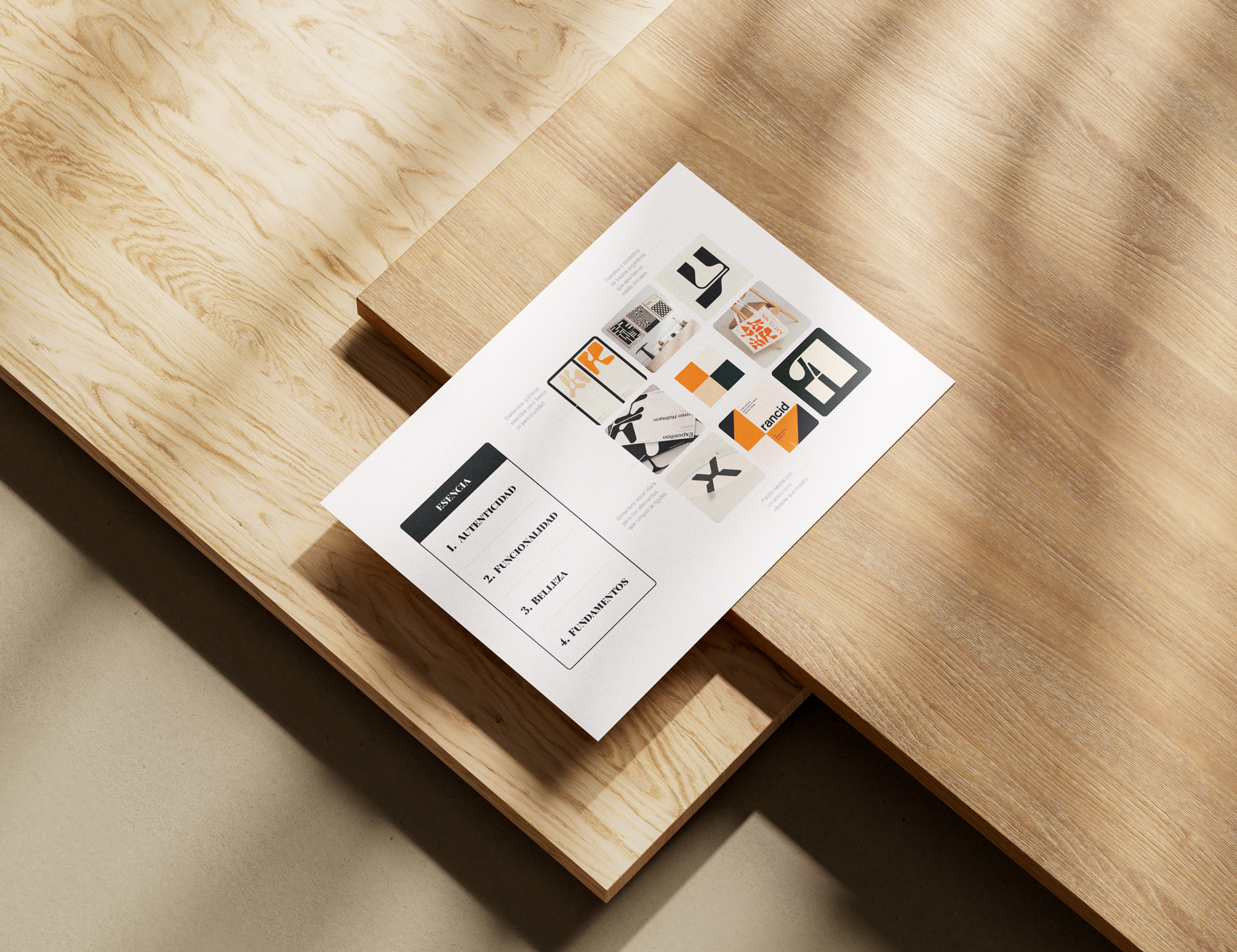 Pieza de papel en una mesa de madera clara con contenido en español y símbolos en blanco, negro, naranja y gris relacionada con conceptos de diseño o comunicación visual.