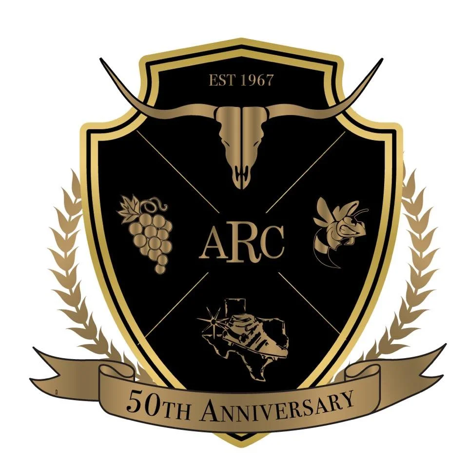 A black and gold emblem with a longhorn skull at the top, a bunch of grapes on the left, a bee on the right, and the Texas state outline with a star in the center at the bottom. The letters 'ARC' are in the middle, and a ribbon at the bottom reads '50th Anniversary'.