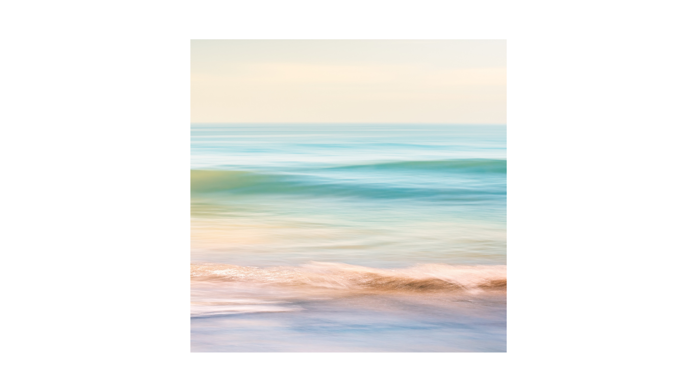 Photo of ocean waves on a beach with pastel colors and gentle surf.