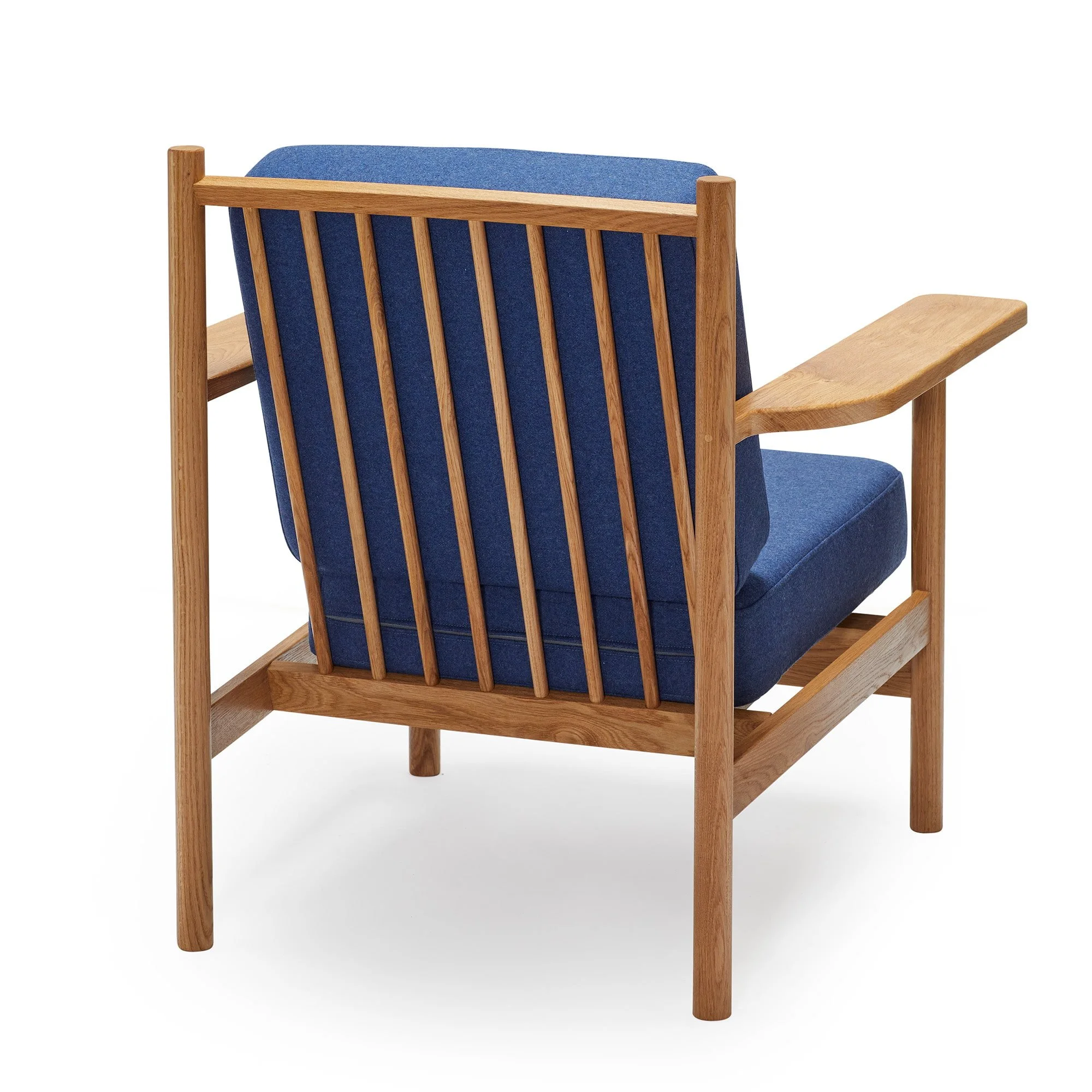 A wooden armchair with a blue cushion and vertical slats on the backrest.