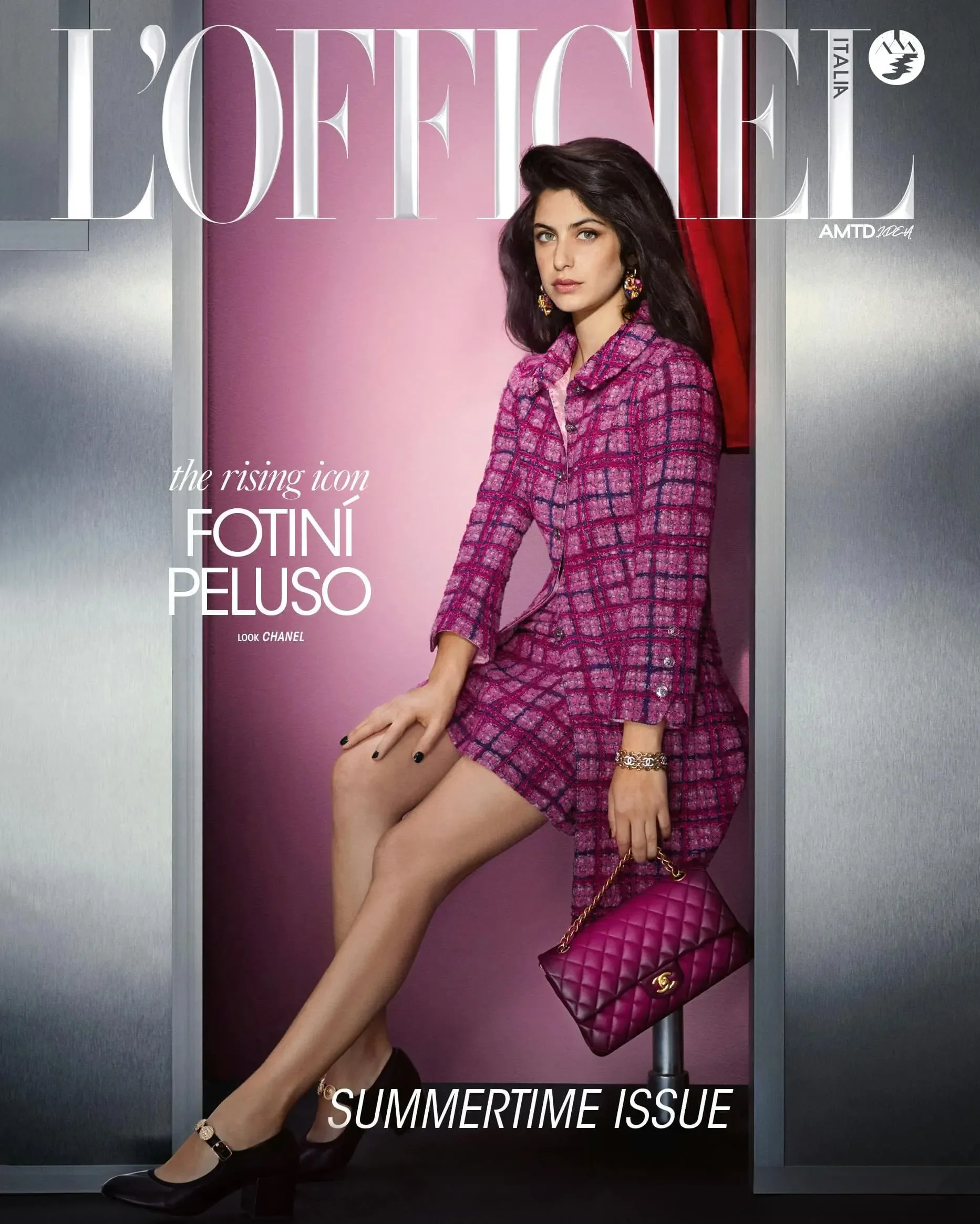 Copertina di L'Officiel Italia Summertime Issue con Fotiní Peluso in tailleur di tweed magenta e borsa matelassé coordinata Chanel all'interno di una cabina fotografica.