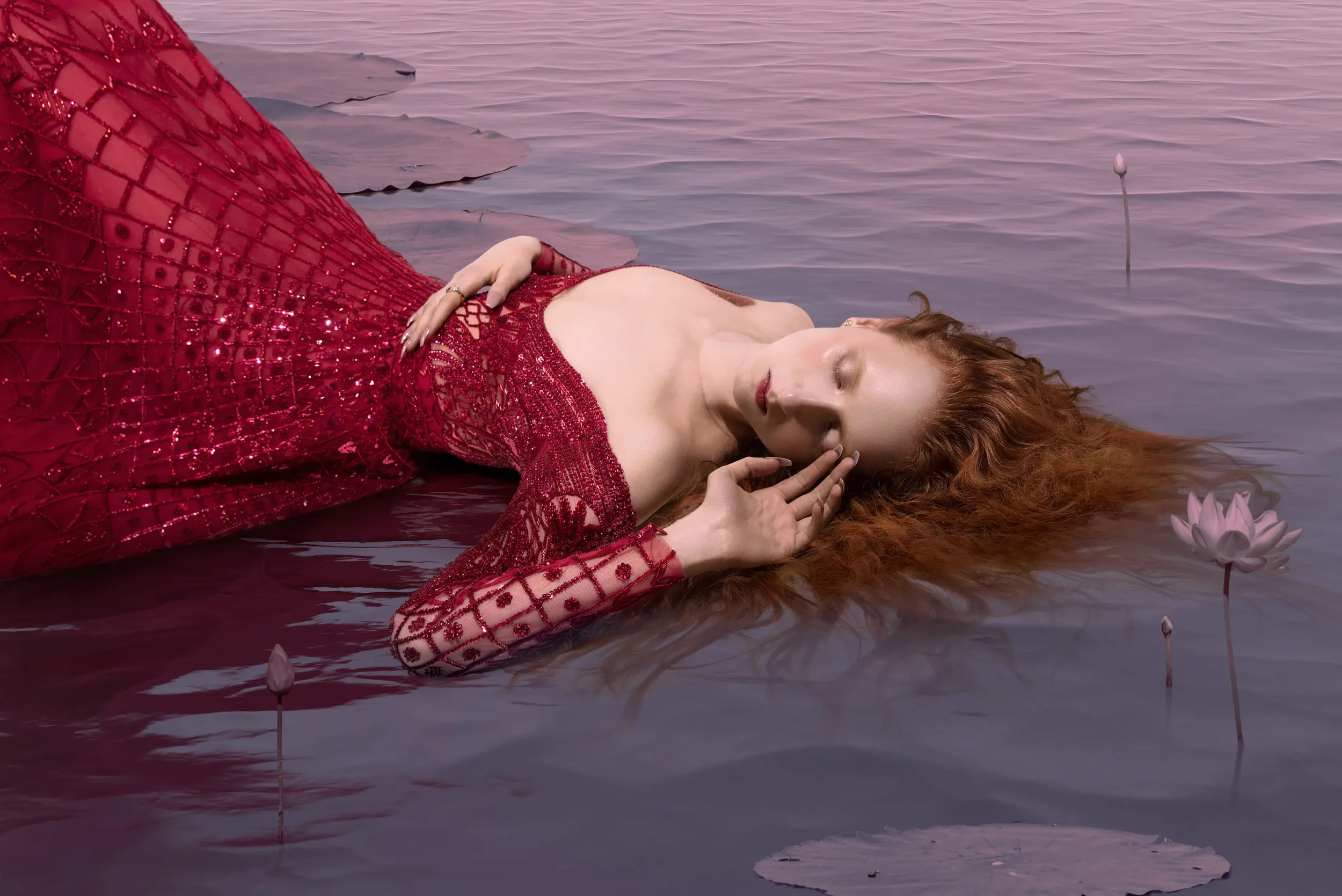 Scatto artistico per Vogue Portugal con modella adagiata nell'acqua tra le ninfee, mentre indossa un sontuoso abito lungo rosso finemente ricamato con trasparenze.