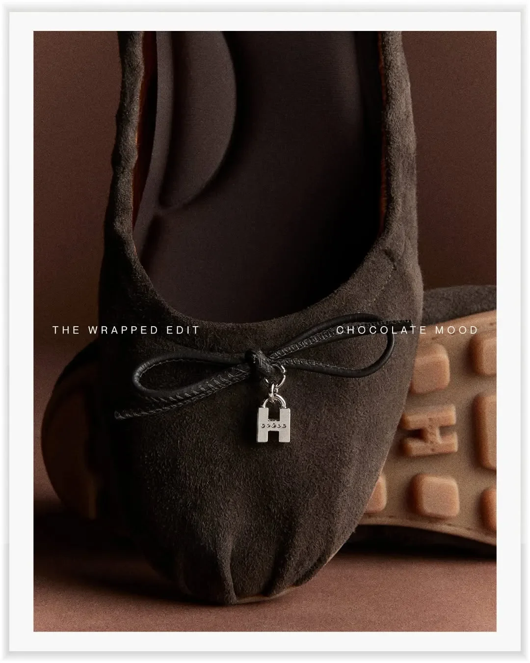 Set design e composizione still life per la campagna ADV Hogan 'Chocolate Mood'. Primo piano di ballerina in camoscio marrone con charm lucchetto con logo H.