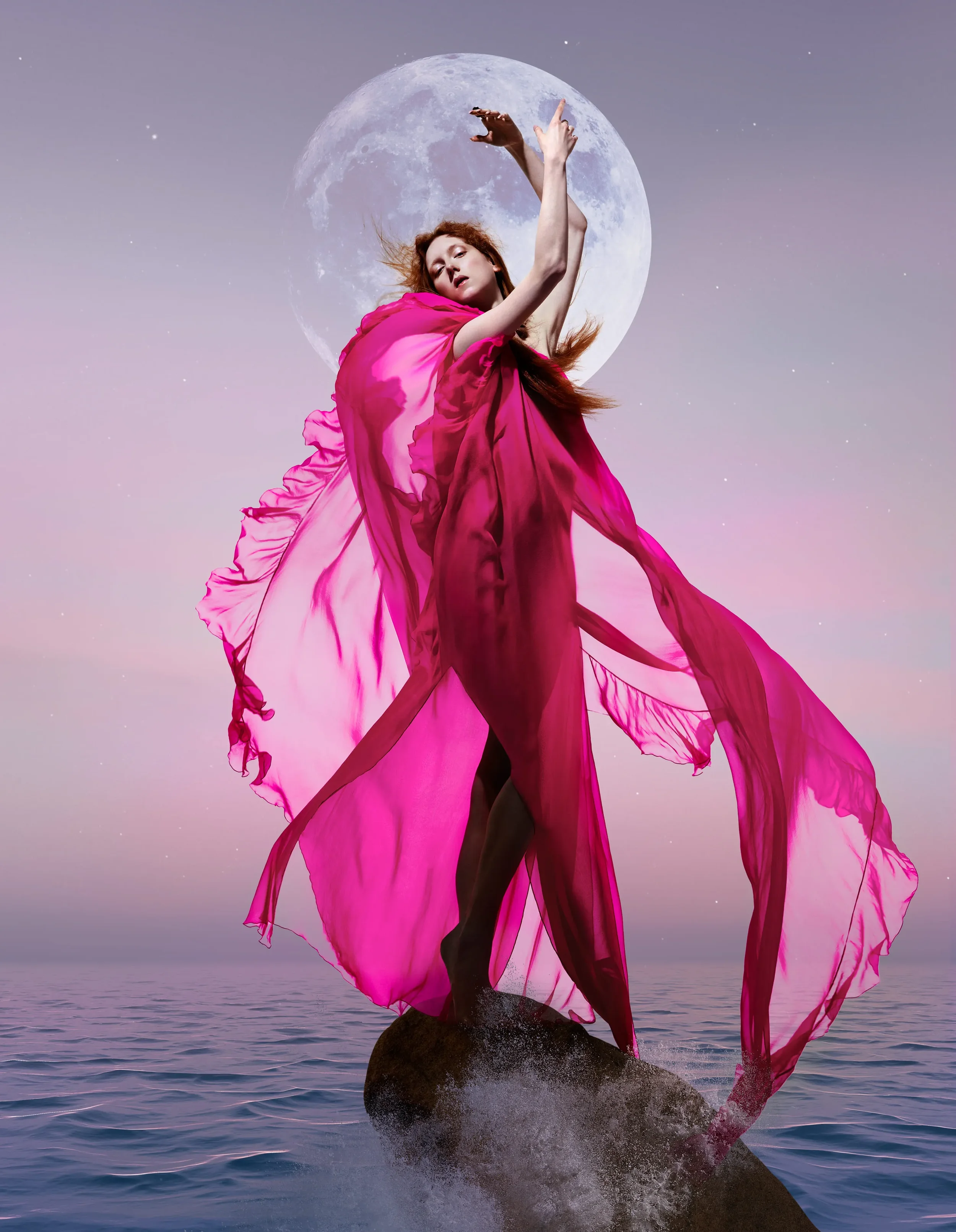 Fotografia di moda ad alto impatto visivo per Vogue Portugal con modella in abito fucsia in chiffon impalpabile su una roccia tra i flutti, sullo sfondo di una grande luna piena.