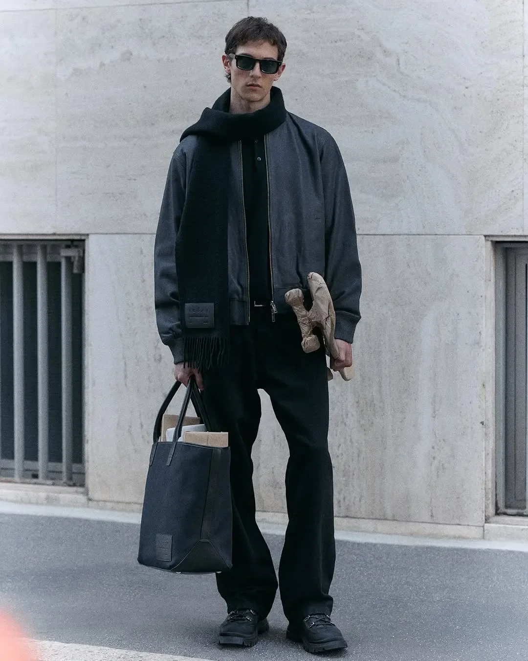 Props styling e direzione artistica per campagna ADV Hogan. Modello uomo con occhiali da sole, borsa tote contenente pacchi regalo e scultura artistica in carta da imballo.