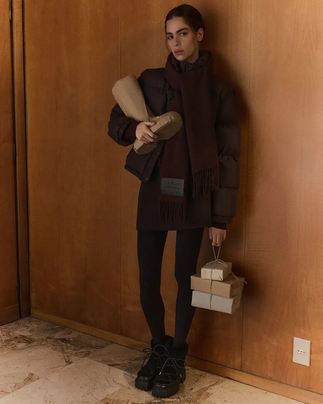 Set design e allestimento props per campagna Hogan. Modella in ambiente interno in legno con pila di pacchi regalo artigianali e stivale modellato in carta da imballo.