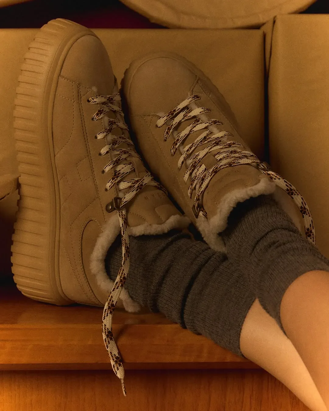 Props styling e inquadratura ravvicinata per la campagna ADV Hogan. Dettaglio di sneakers beige in camoscio con interno in montone e lacci intrecciati