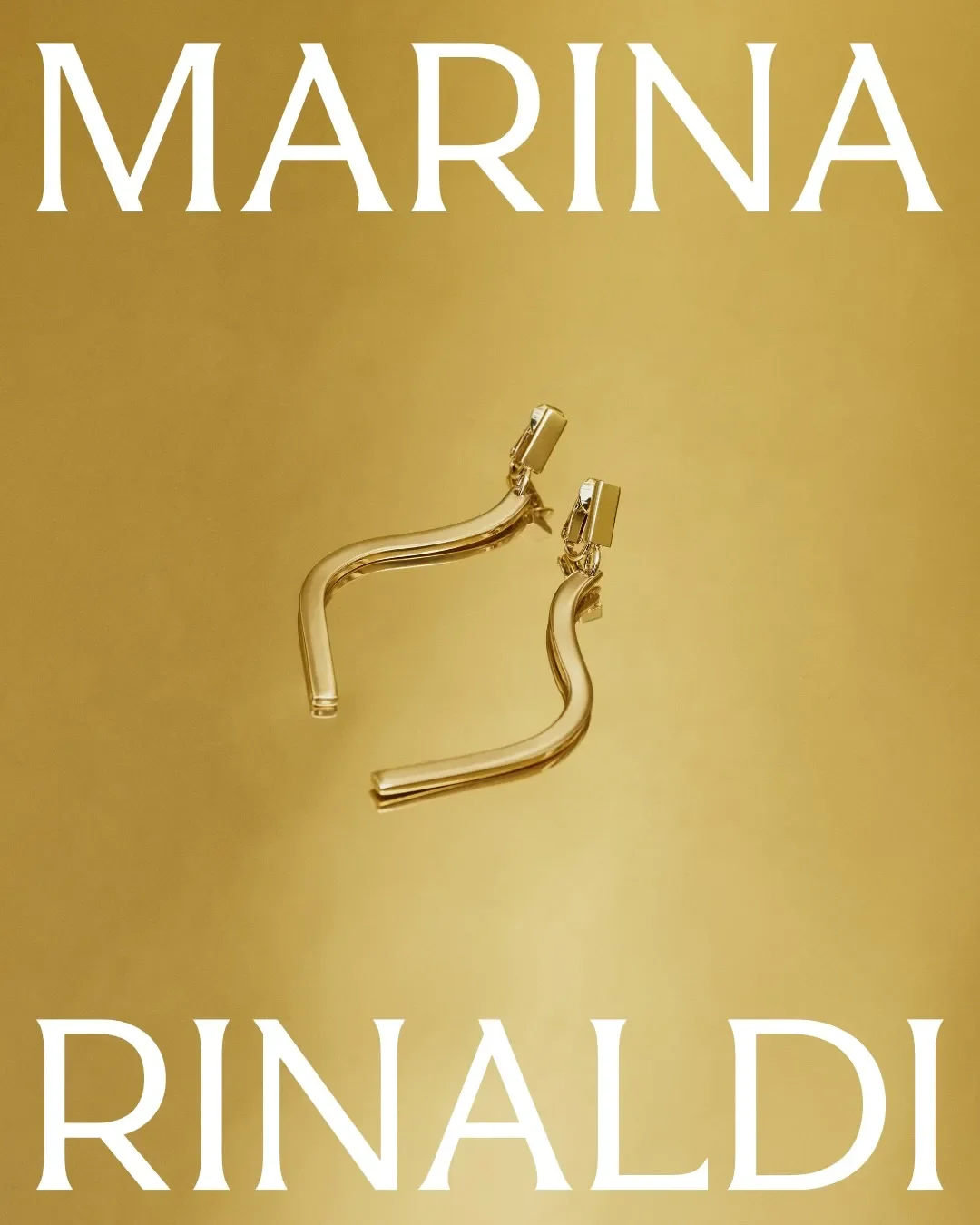 Scatto still life di dettaglio con orecchini dorati scultorei a forma d'onda posizionati su una superficie riflettente oro, completato dalla titolazione grafica del brand Marina Rinaldi.