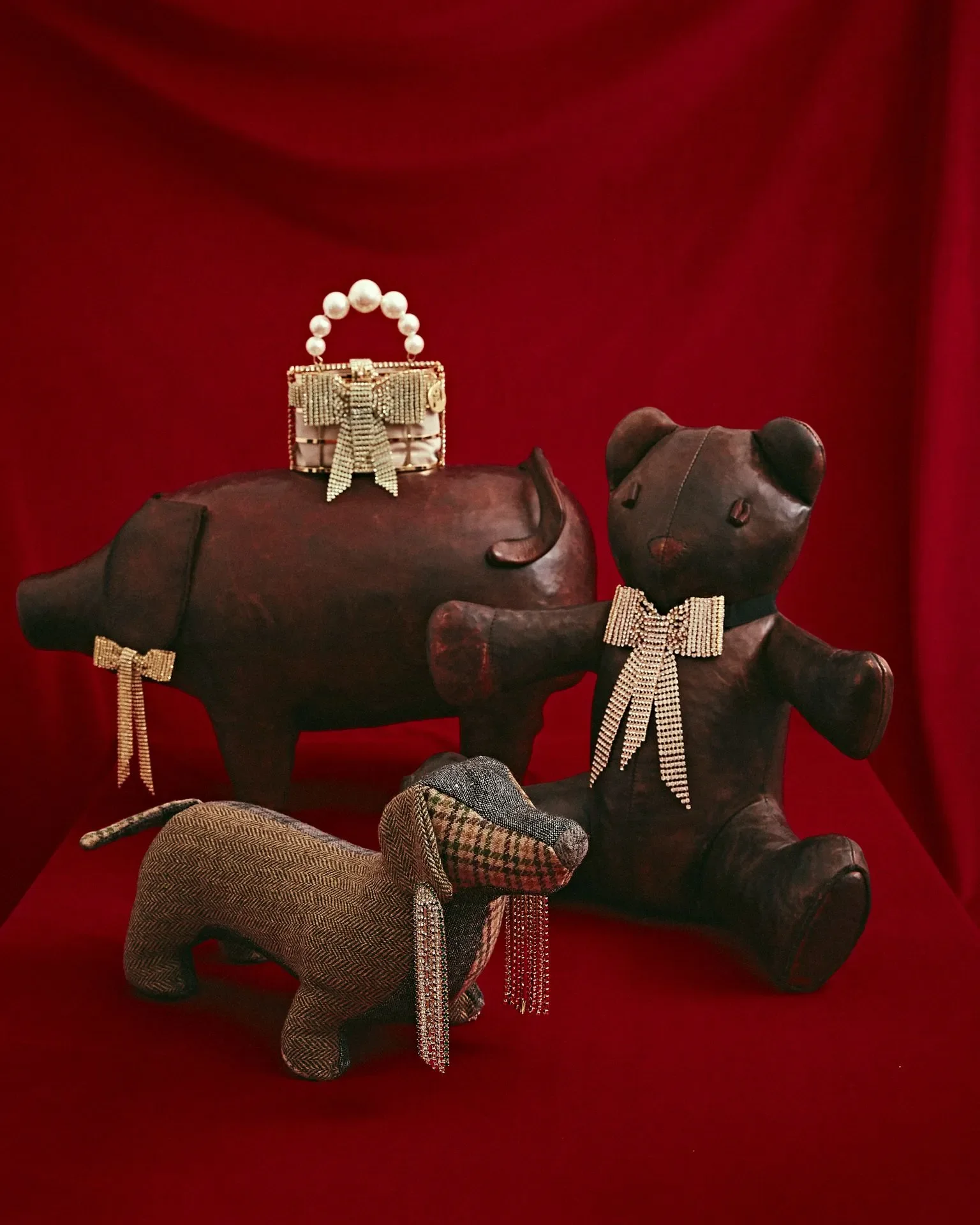 Composizione still life per la campagna Rosantica con miniature di animali in pelle impreziosite da fiocchi di cristallo e mini borsa di perle.