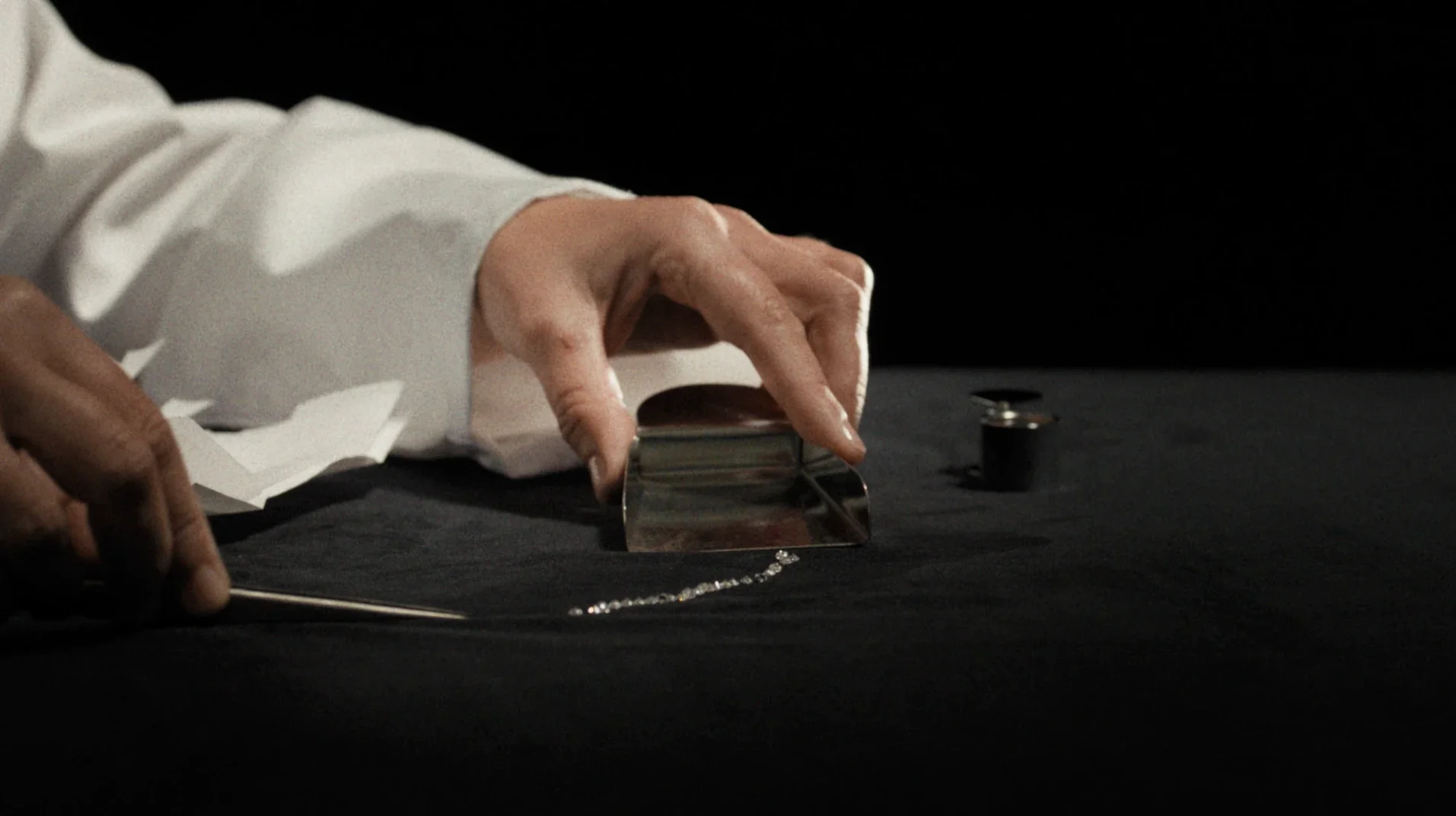 Primo piano di un gemmologo che seleziona accuratamente diamanti e pietre preziose con pinzette e palette da laboratorio per Ralph Lauren Fine Jewelry.
