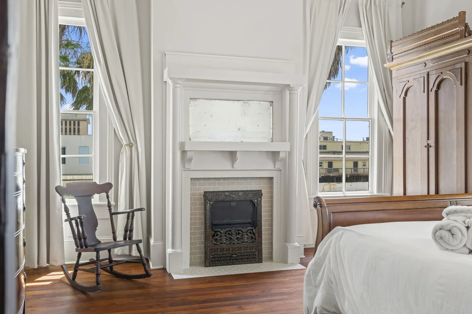 The Mollie Walters Pearl Chamber, a fireplace, and brown wooden armoire.