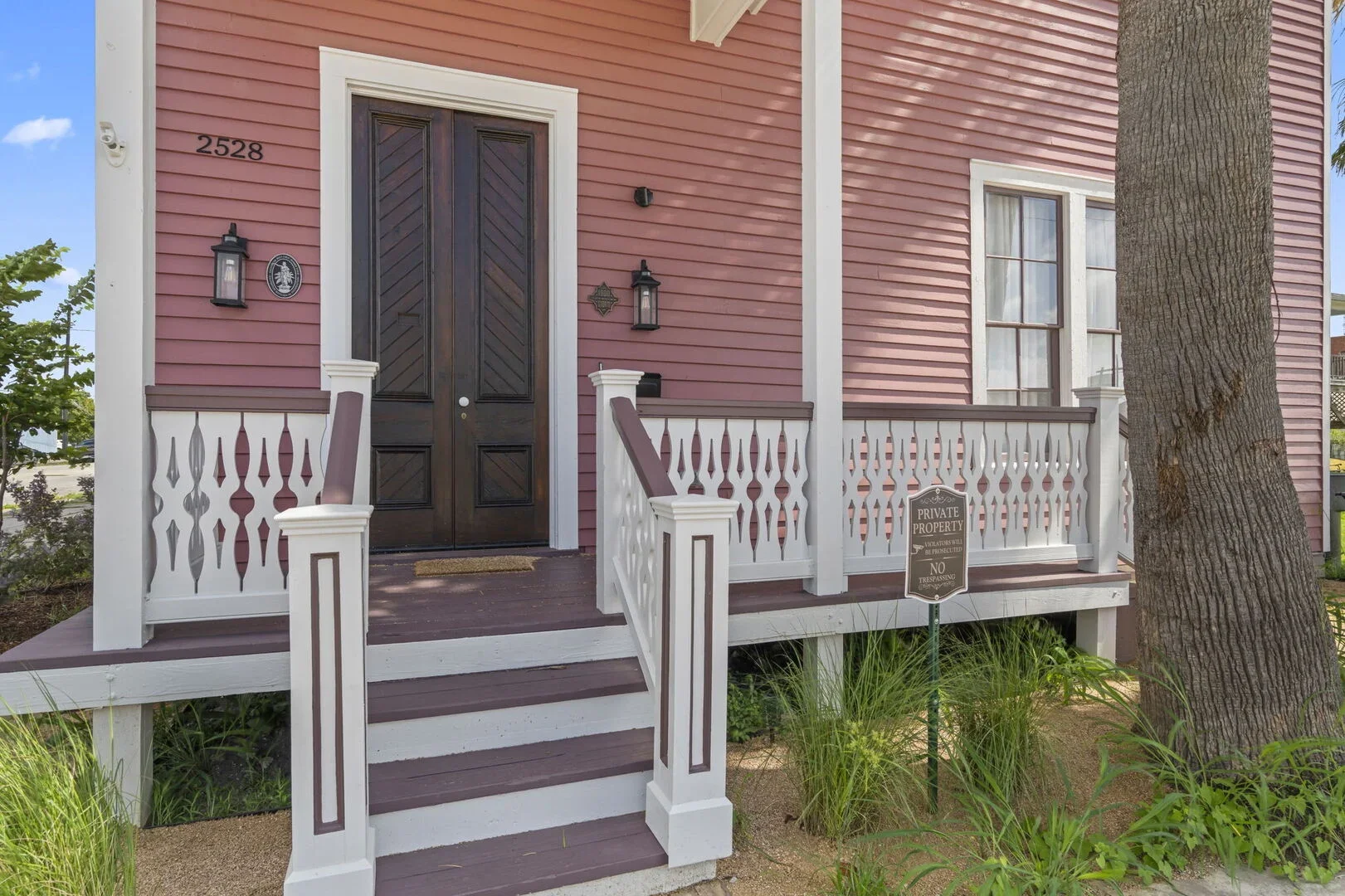 Mollie Walters House porch with white railing, two lantern-style lights