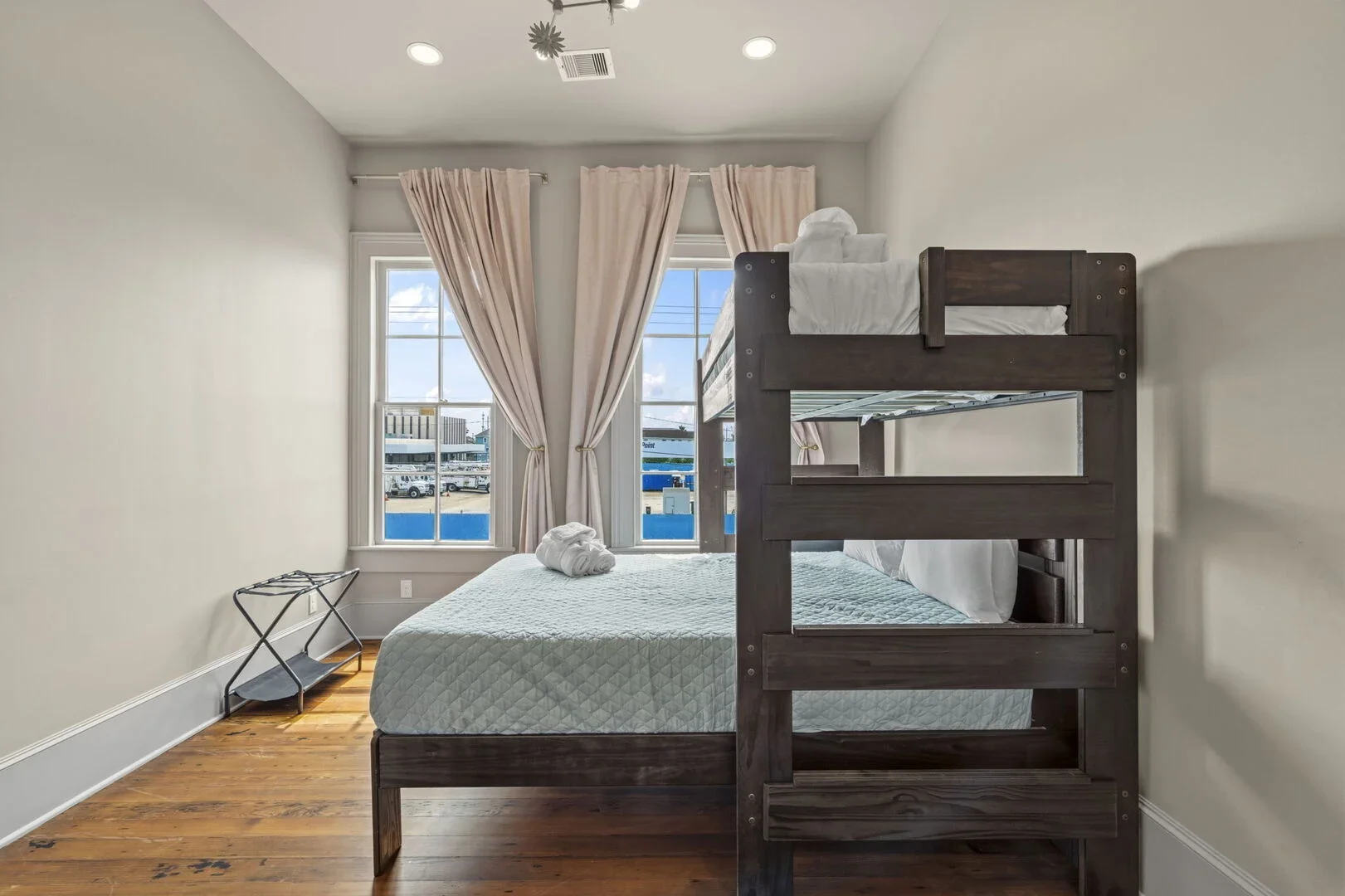The Mollie Walters Mauve Chamber with a twin over queen bunk bed and a luggage rack