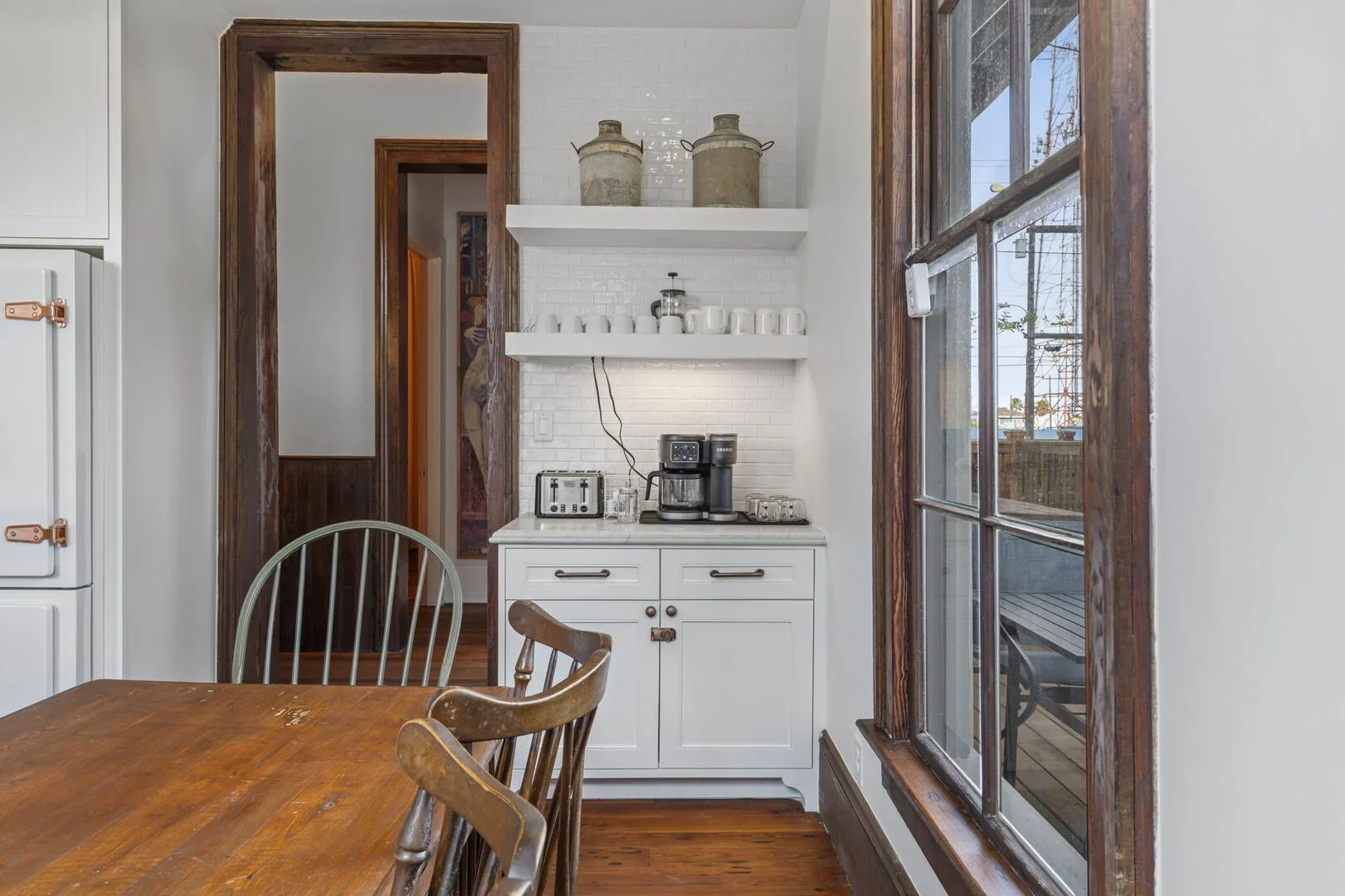 Mollie Walters House Kitchen corner with white cabinets, stainless steel coffee maker, toaster, and glassware on the countertop