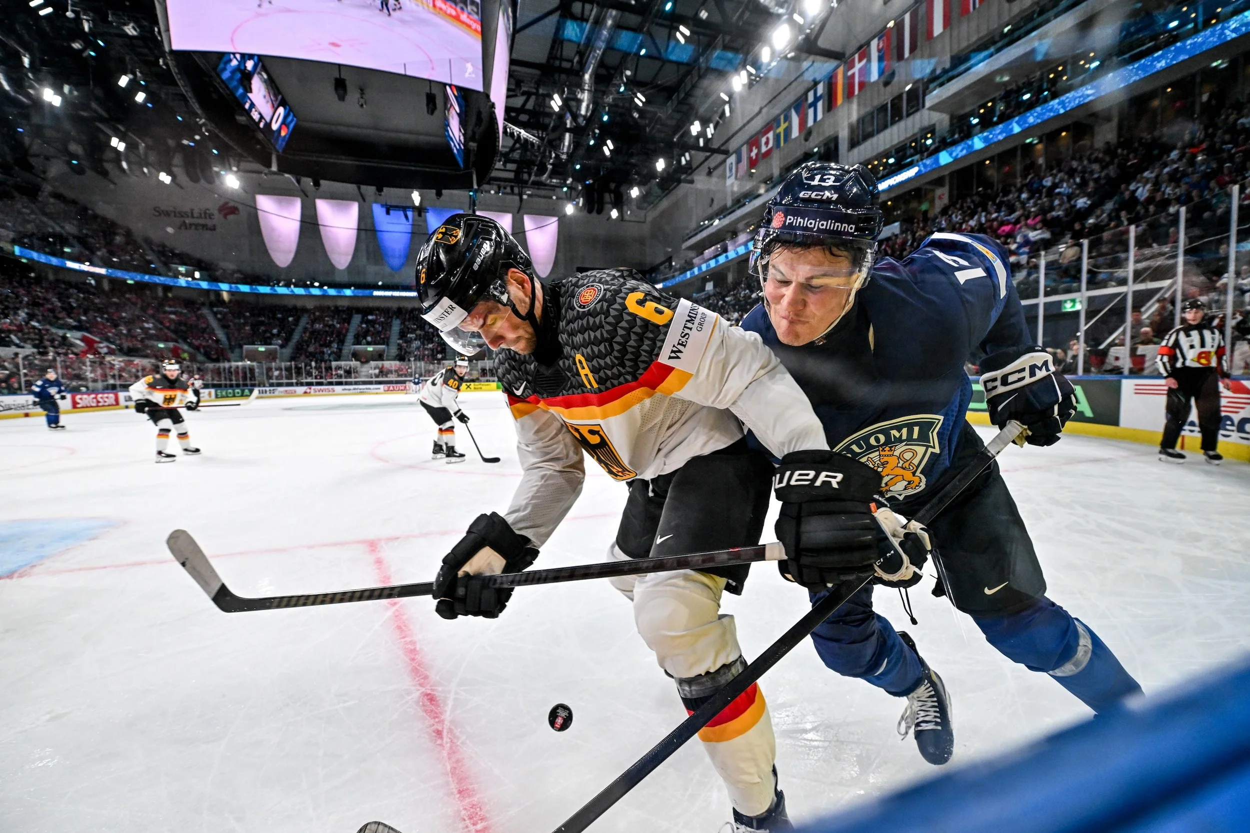  Jesse Puljujärvi and Kai Wissmann fight for the puck along the boards 