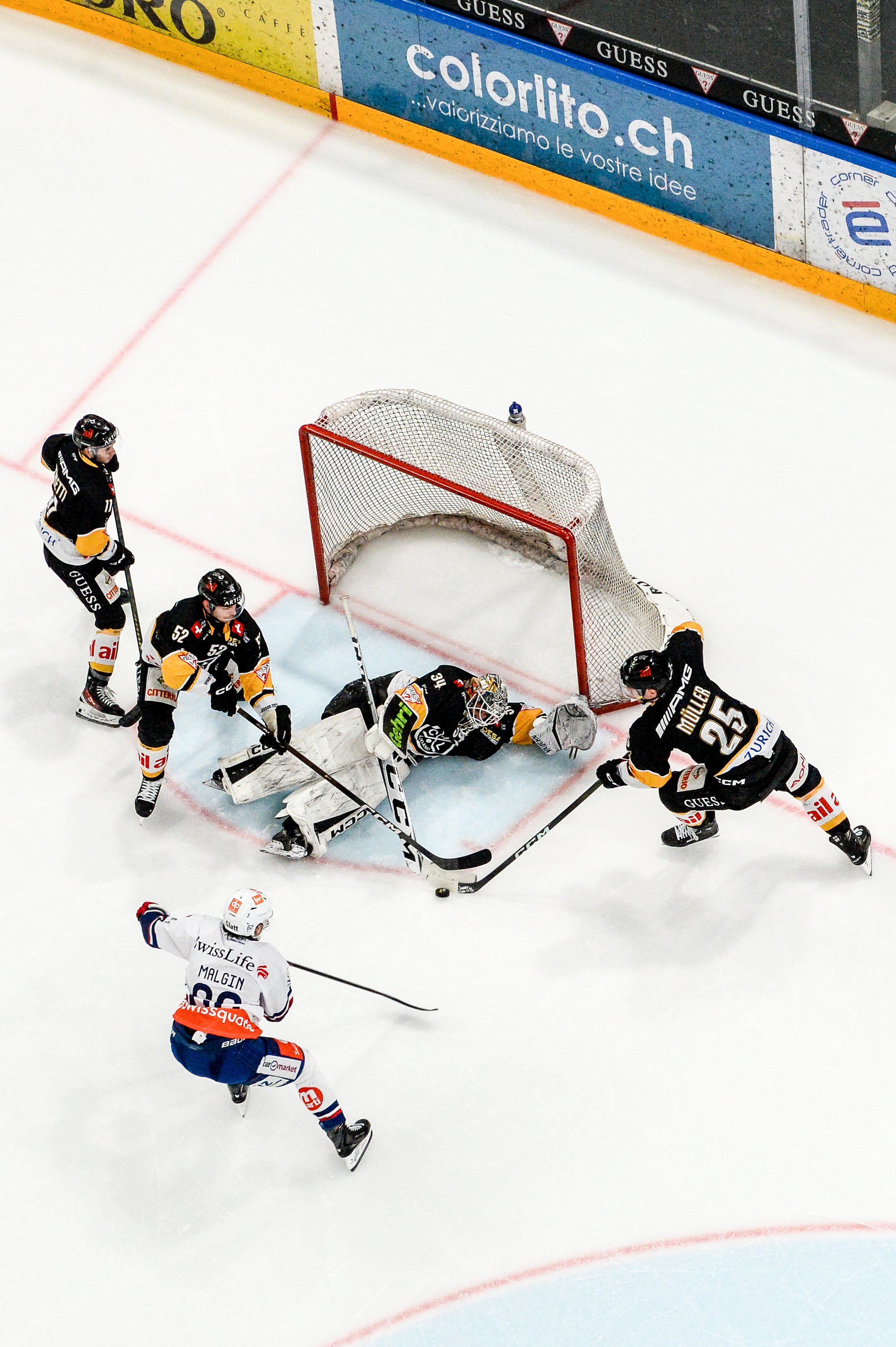  Goaltender Niklas Schlegel is helped by his teammates as they try to stop Denis Malgin 